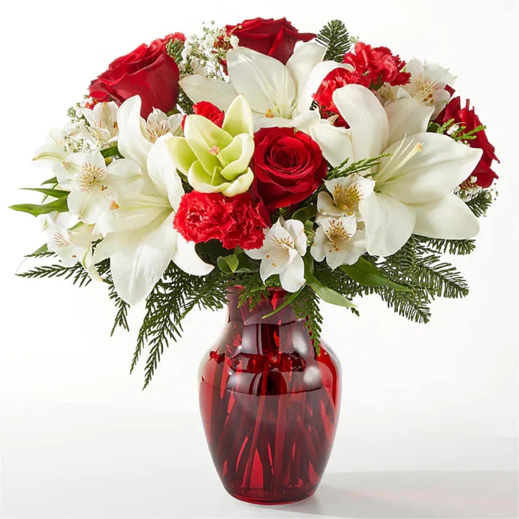 Bouquet of red roses, white lilies, and carnations in a red glass vase