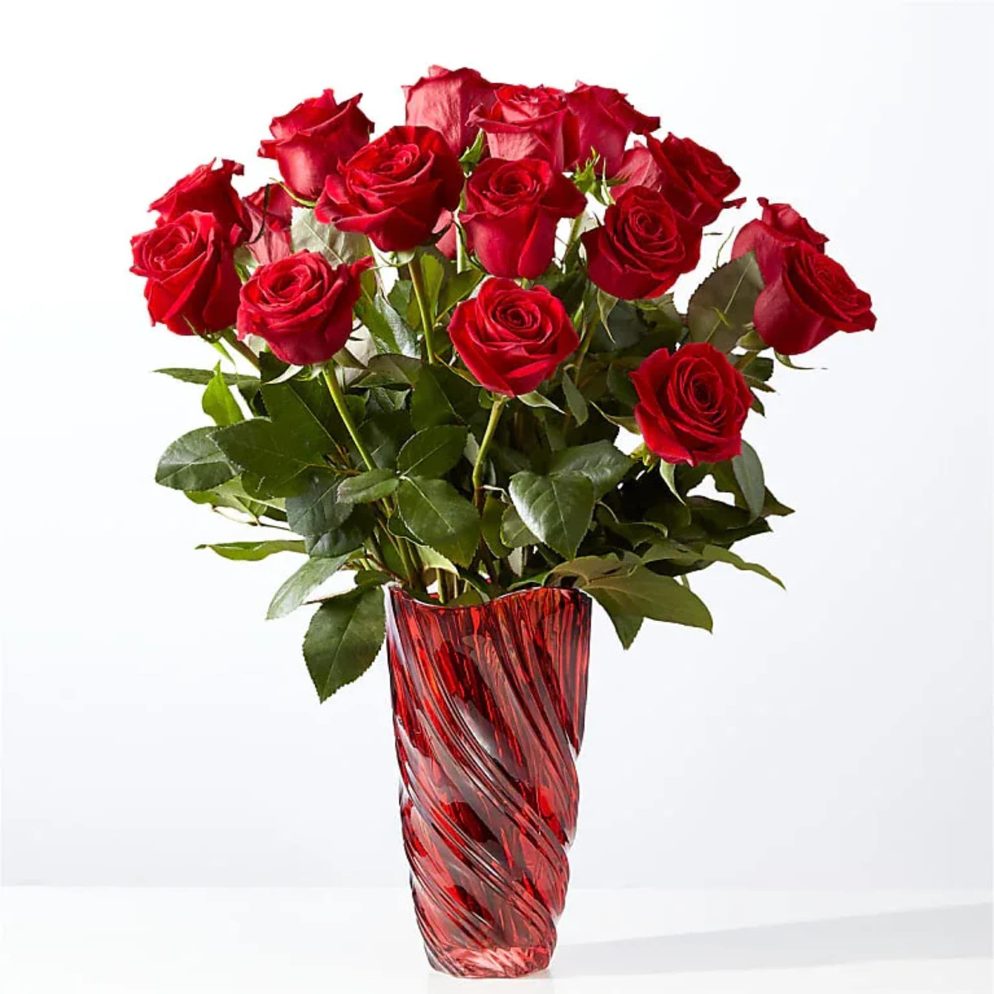 Red roses arranged in a red glass vase