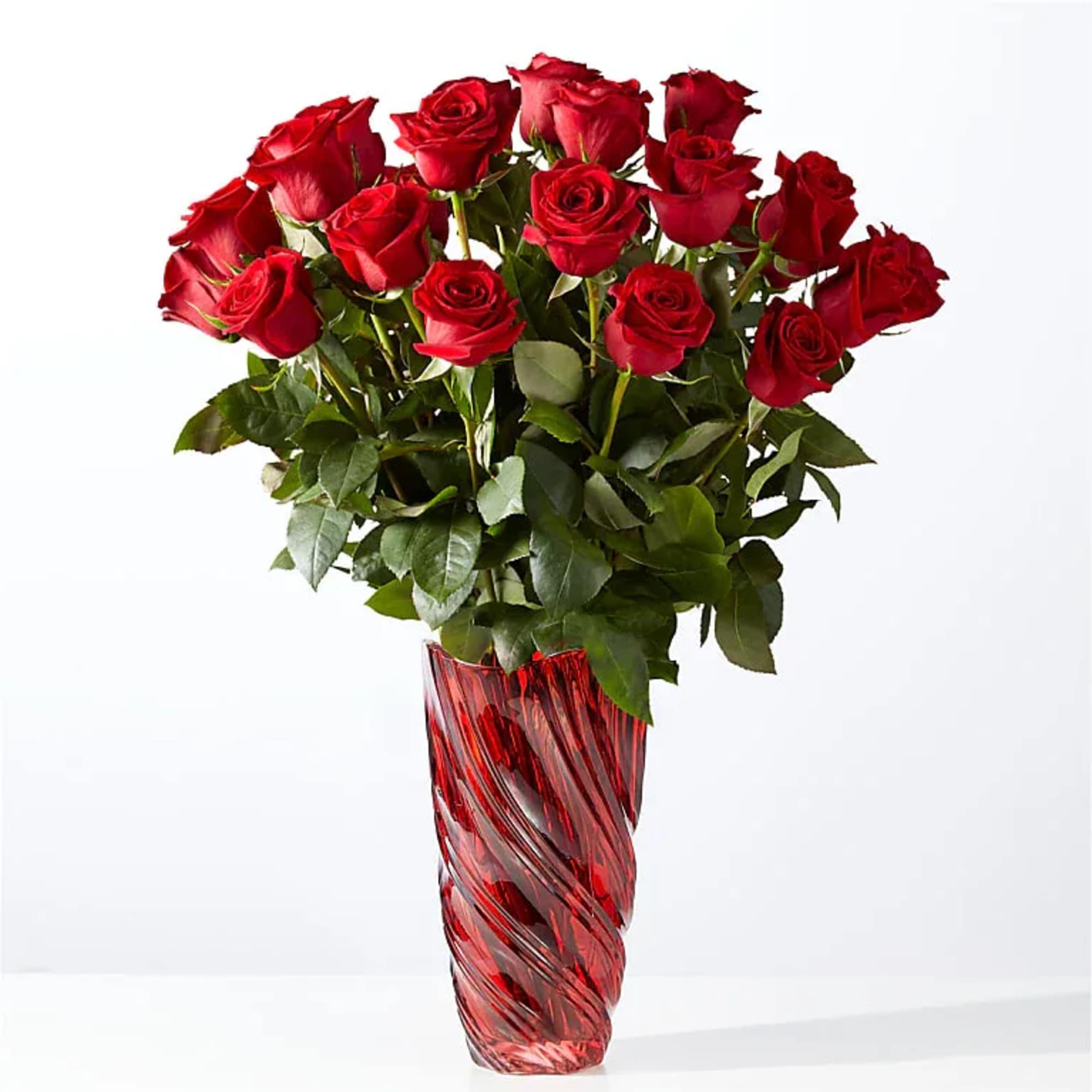 Red roses arranged in a tall red glass vase