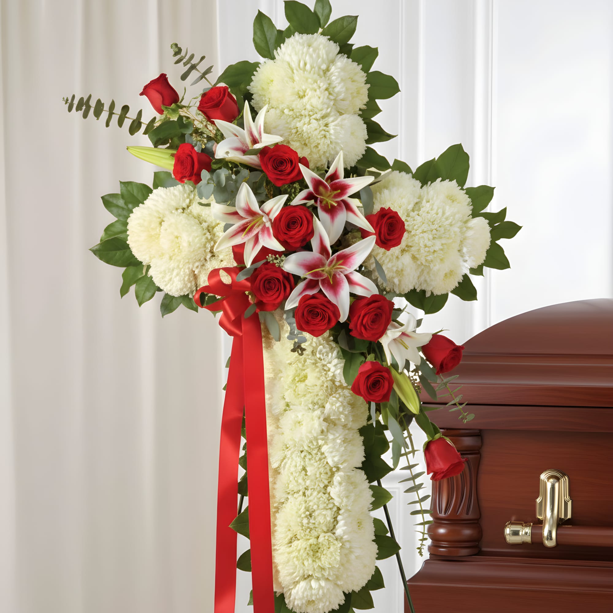 Dense white carnations shaped into a dignified standing cross create a solemn