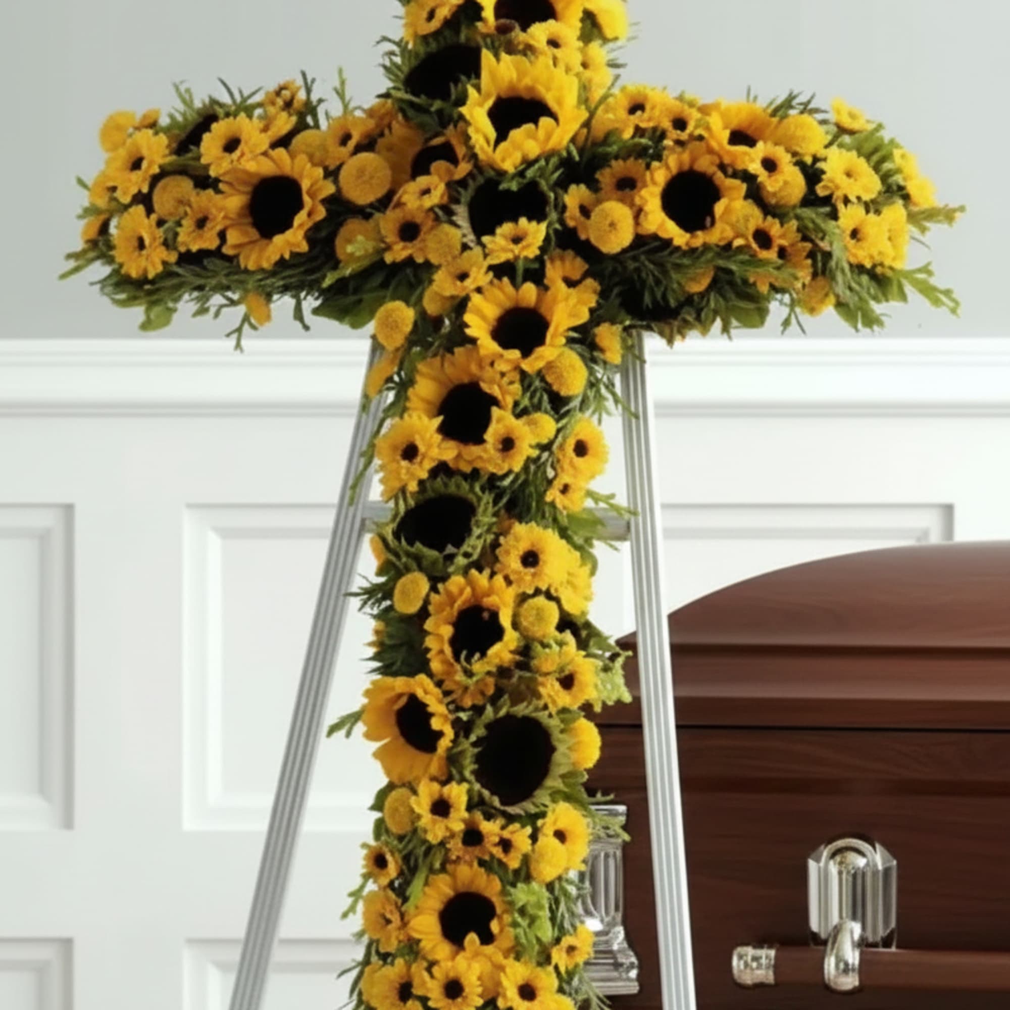 A radiant standing cross of sunflowers, daisies and chrysanthemums designed as a
