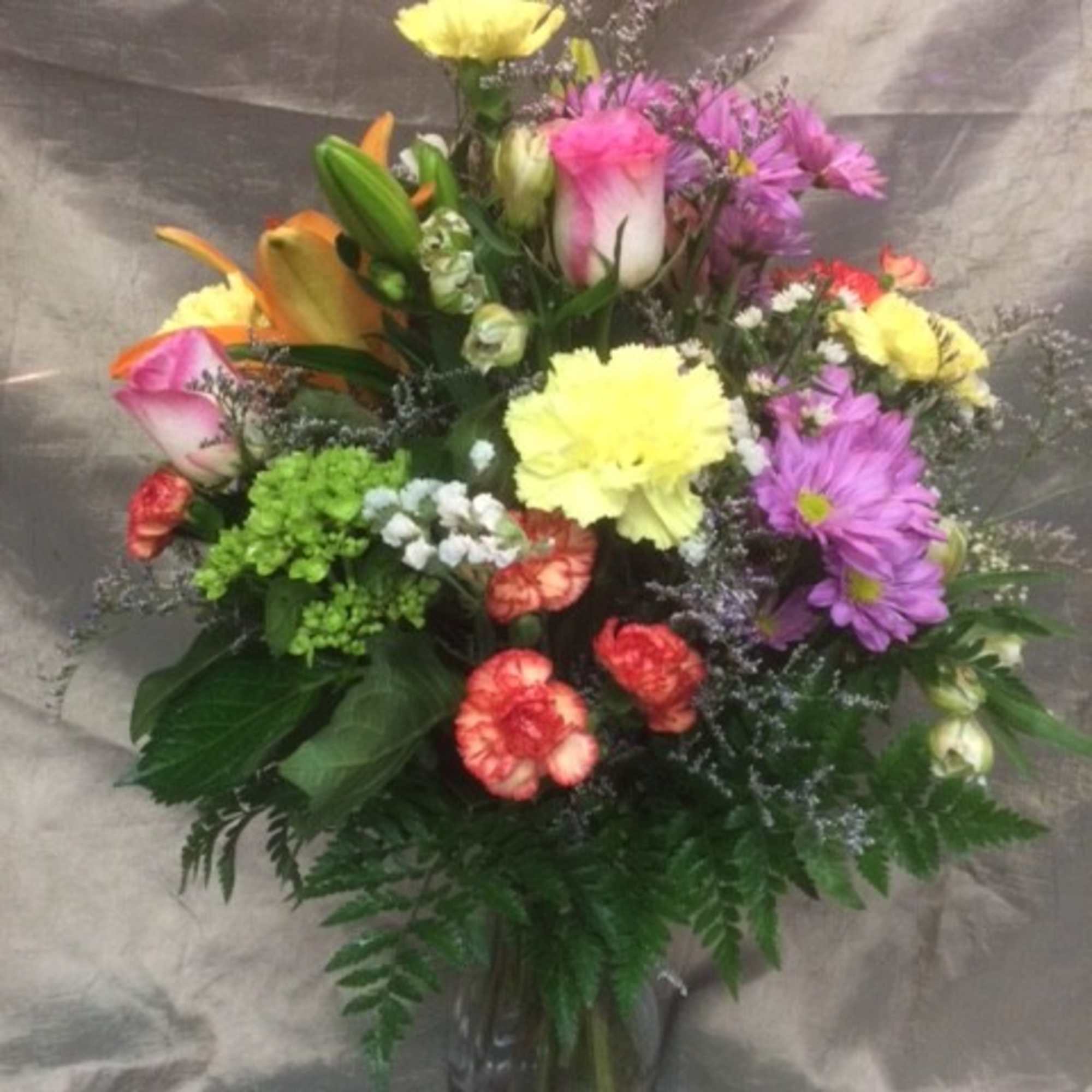 Mixed bouquet of colorful flowers in a glass vase