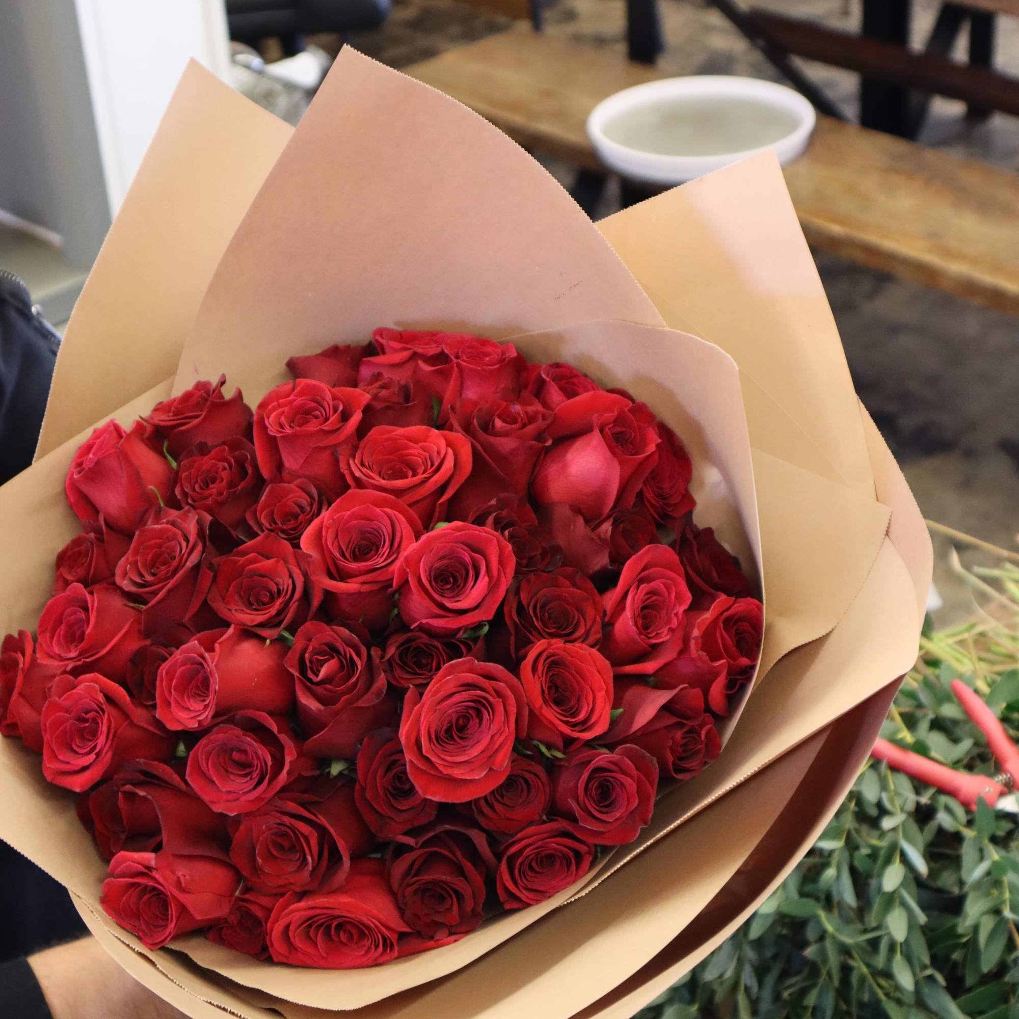 Bouquet of red roses wrapped in tan paper