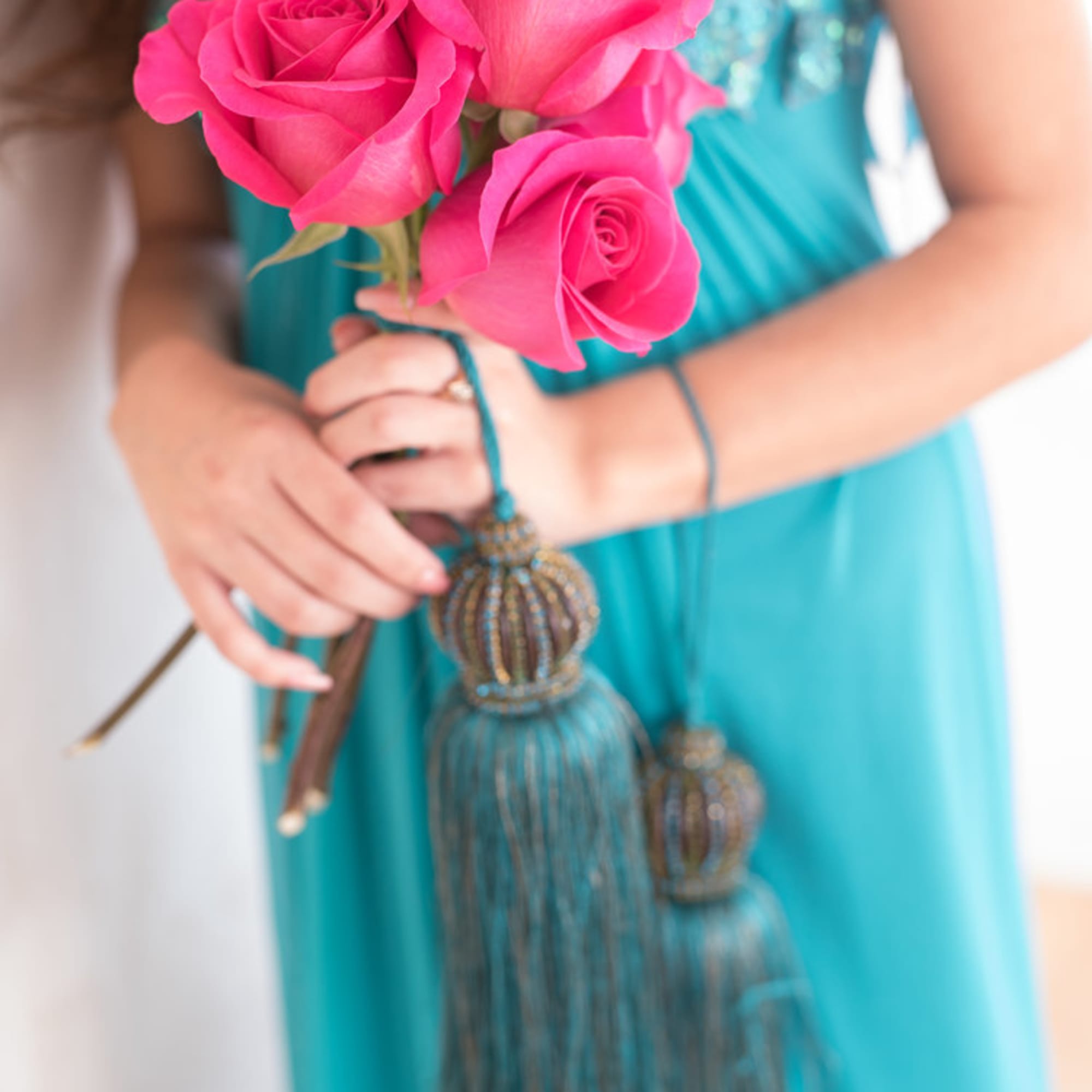 Pink roses held by a person in a turquoise dress