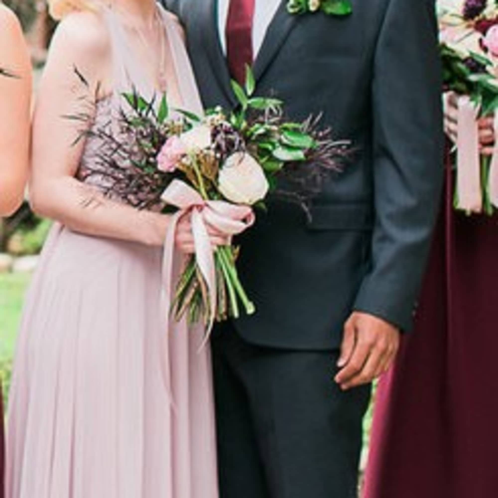 Wedding party members holding bouquets and wearing boutonnieres
