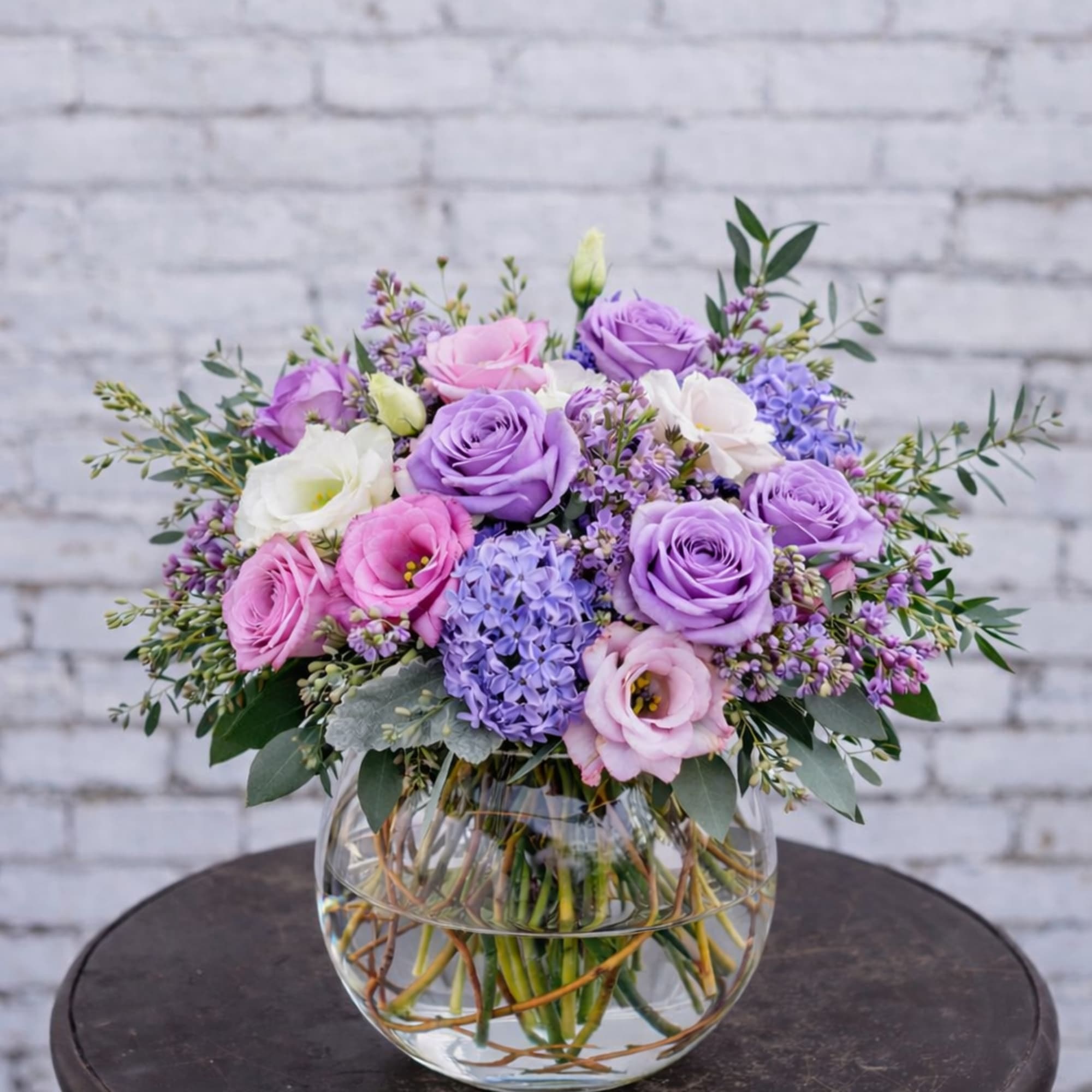 Bouquet of pink and purple roses in a clear glass vase