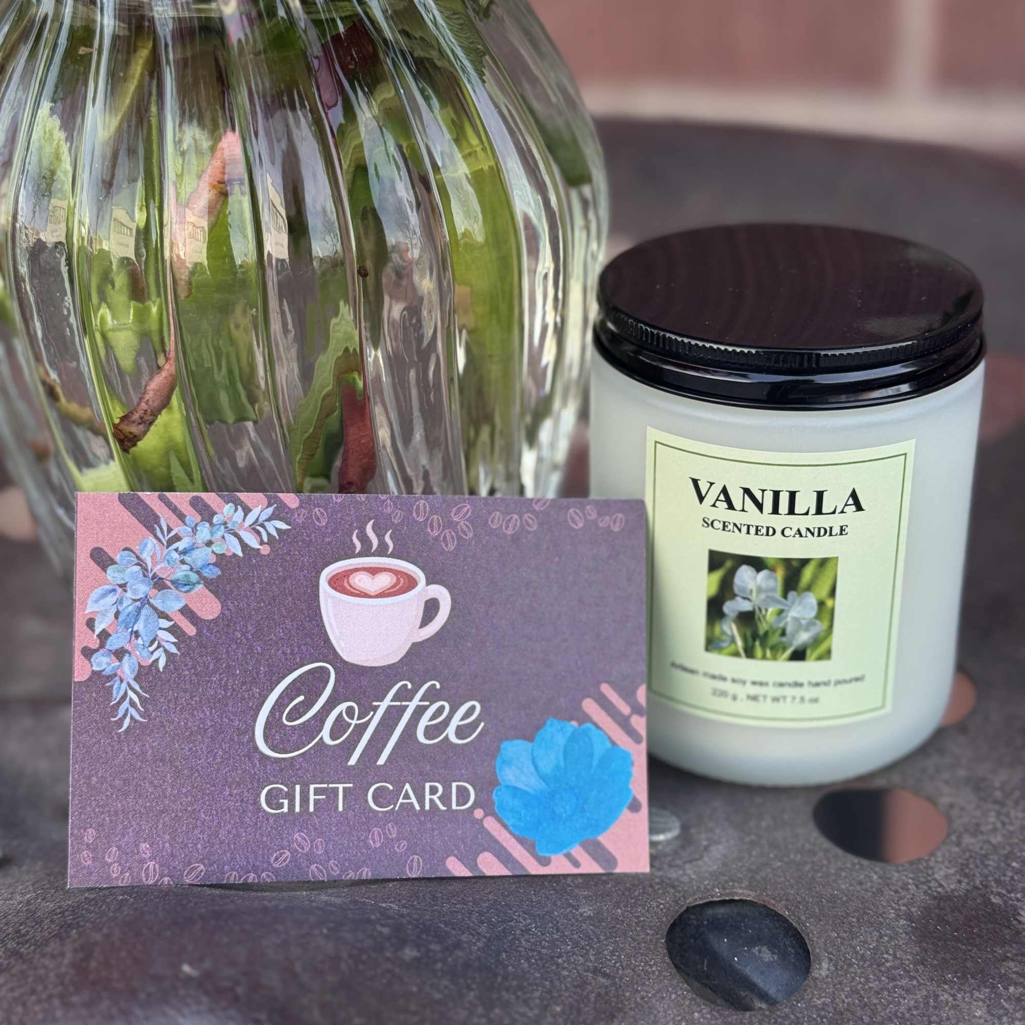 Coffee gift card beside a vanilla scented candle and a wrapped floral vase