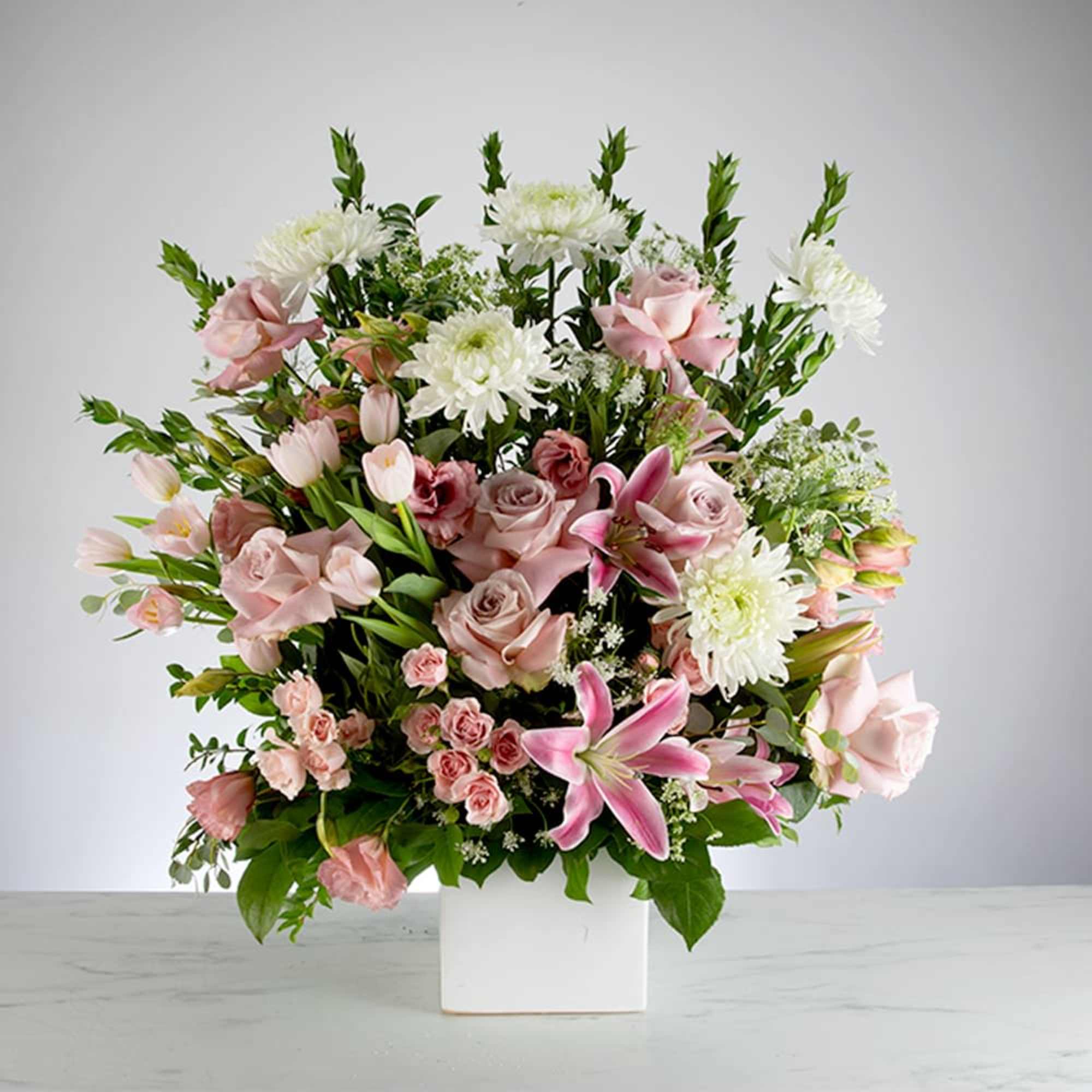 Pink and white mixed flower arrangement in a white vase