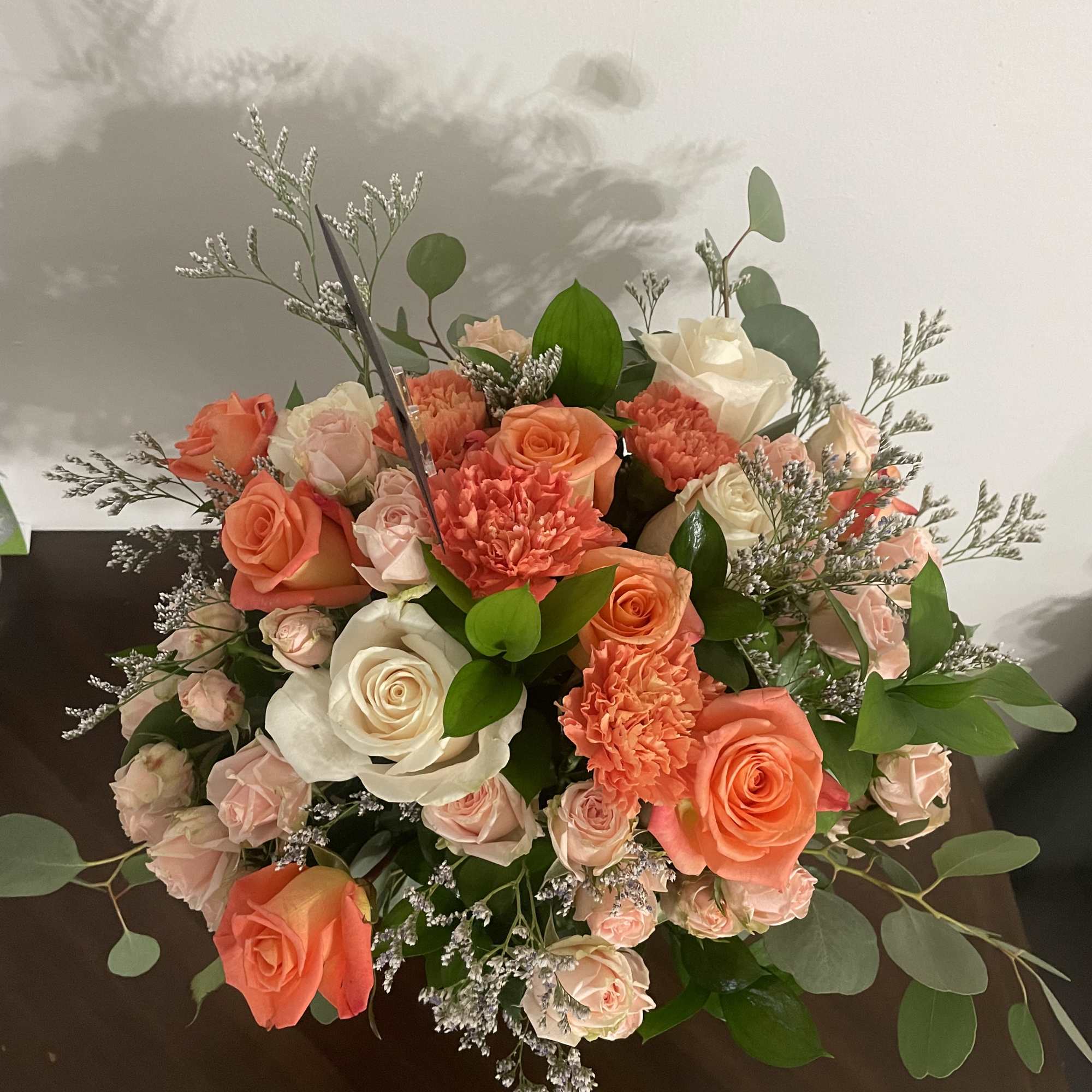 Bouquet of coral and white roses with carnations and greenery