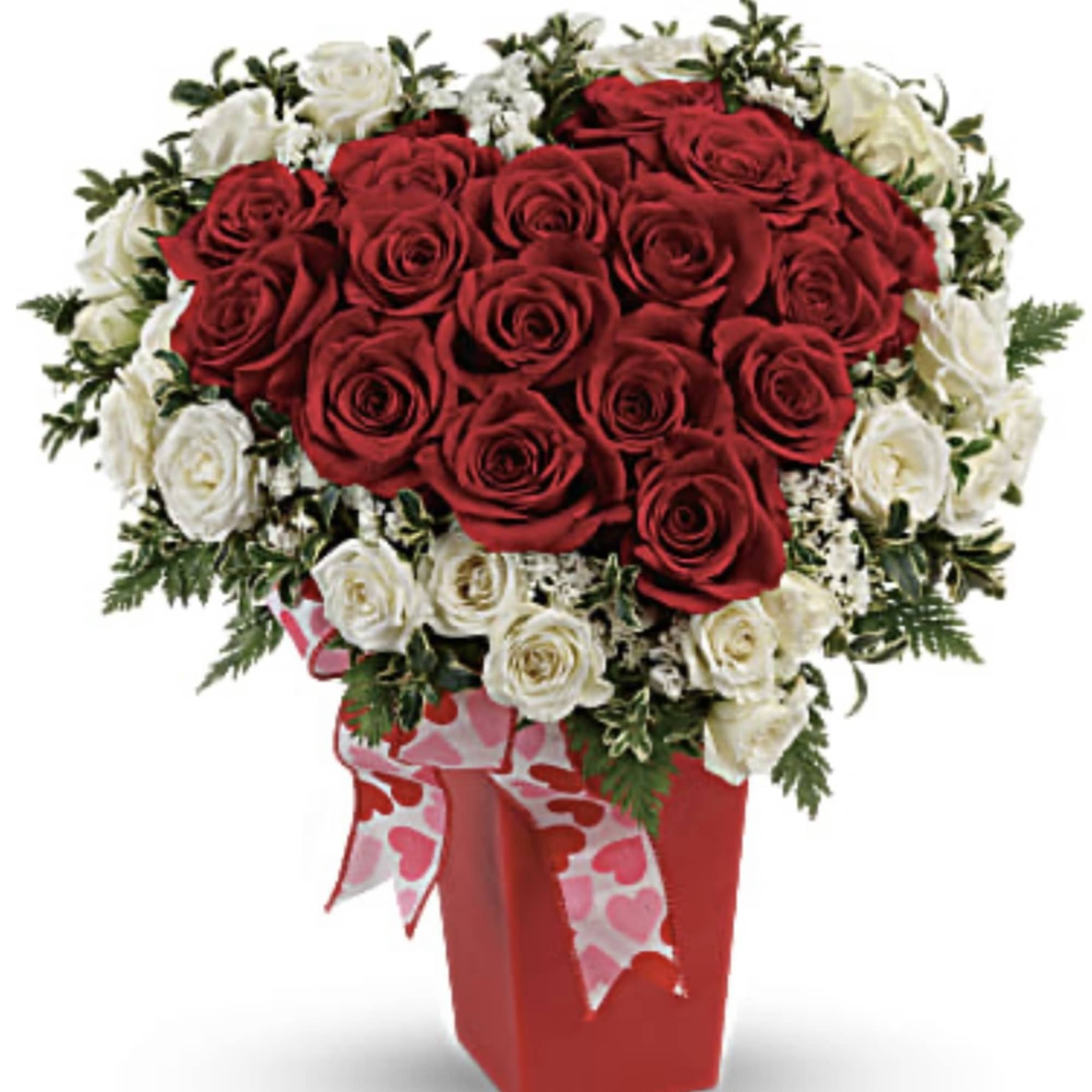 Red and white rose arrangement in a red vase with heart ribbon
