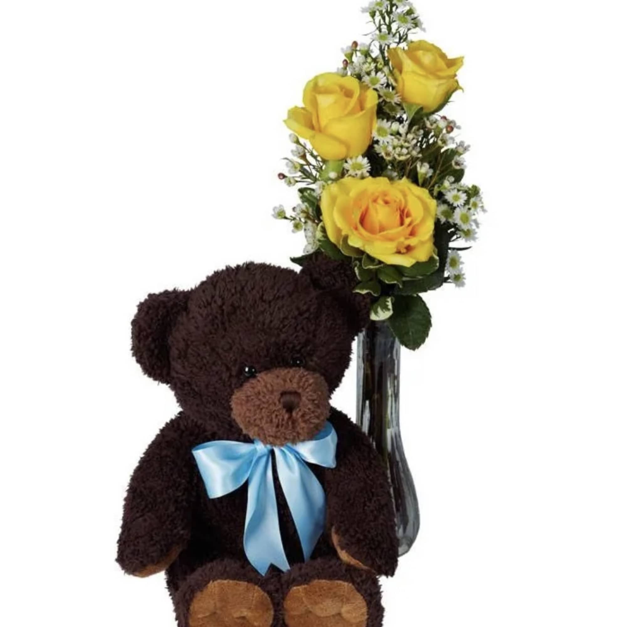 Teddy bear beside yellow roses in a glass vase