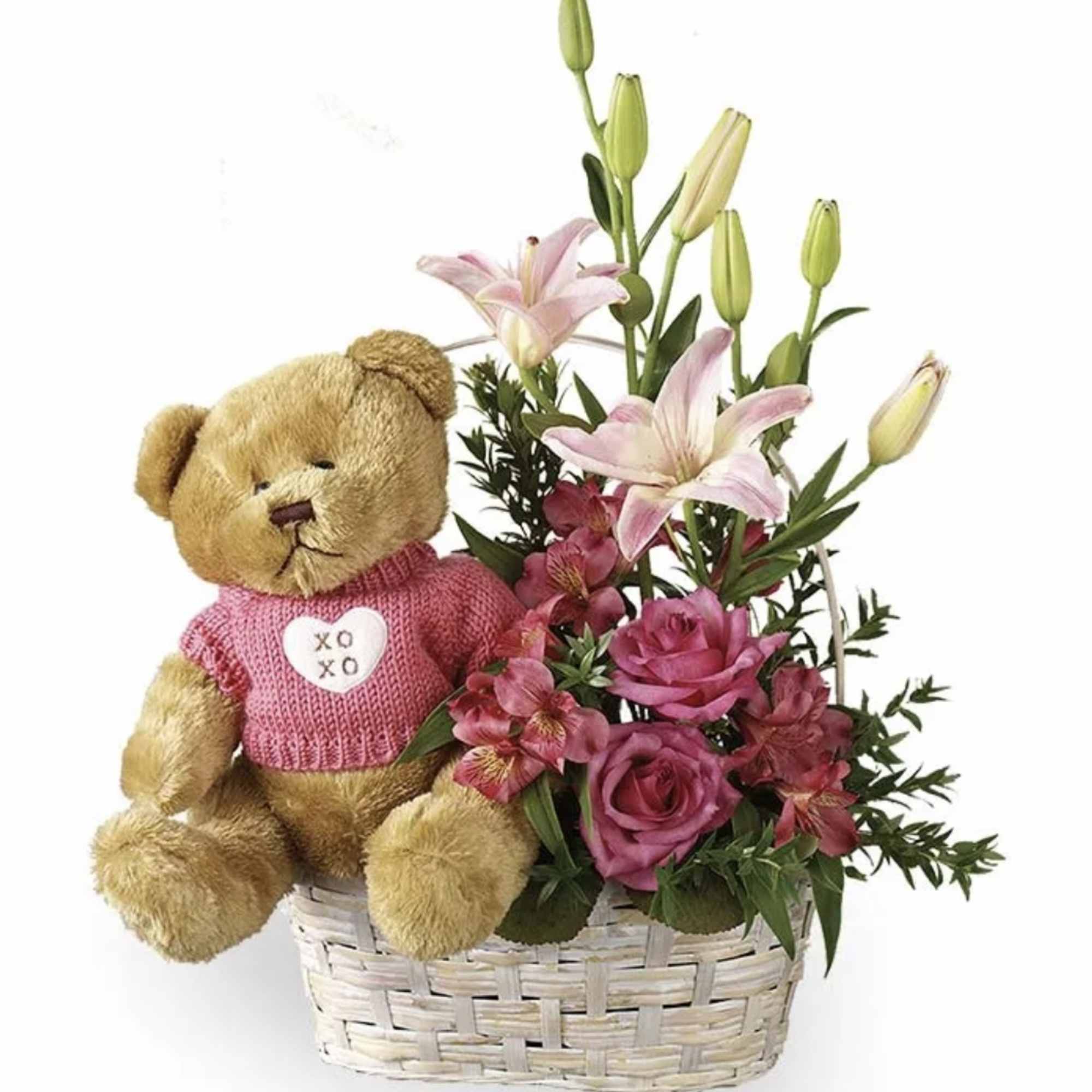 Teddy bear in a basket with pink flowers and lilies