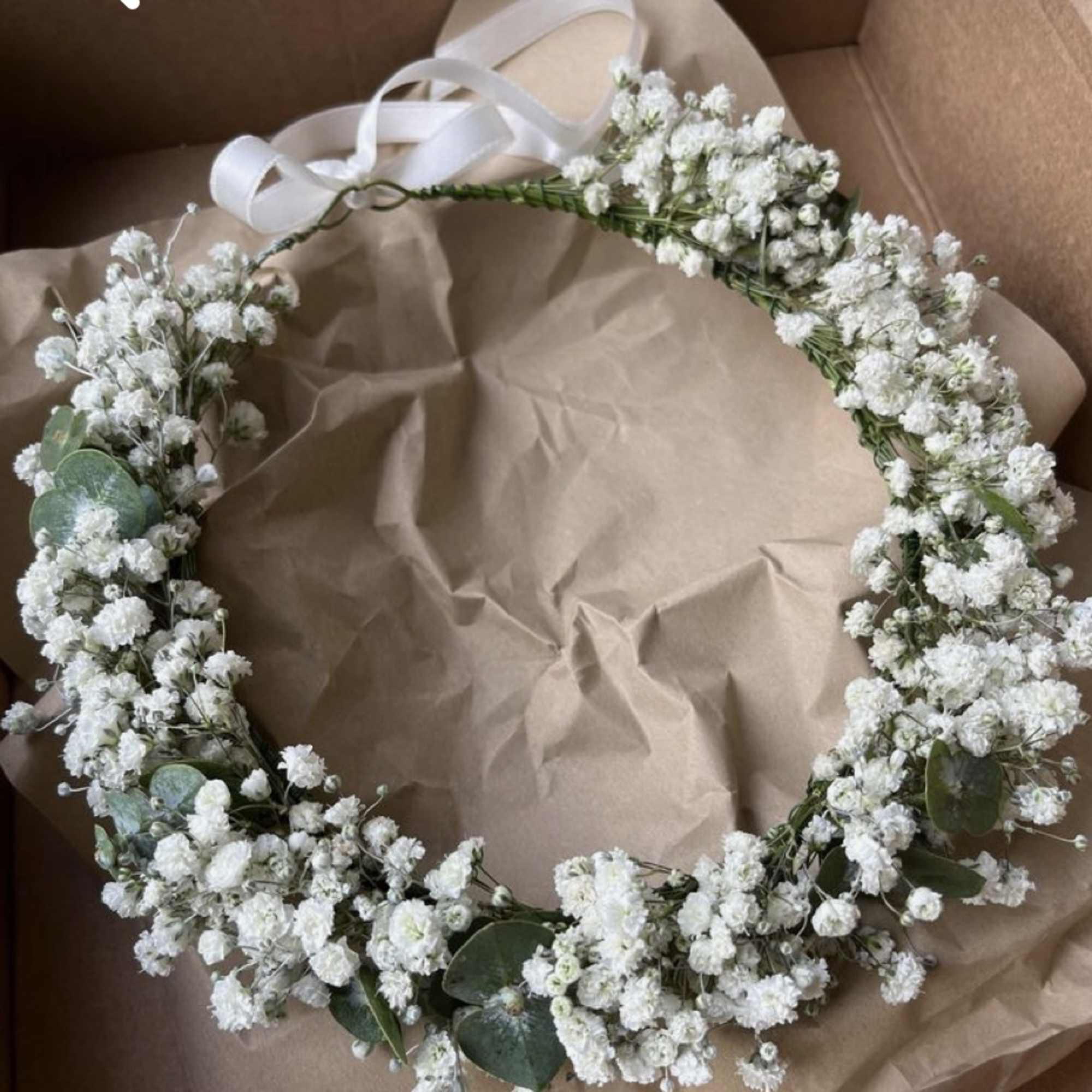 White baby's breath floral crown with ribbon ties in a box