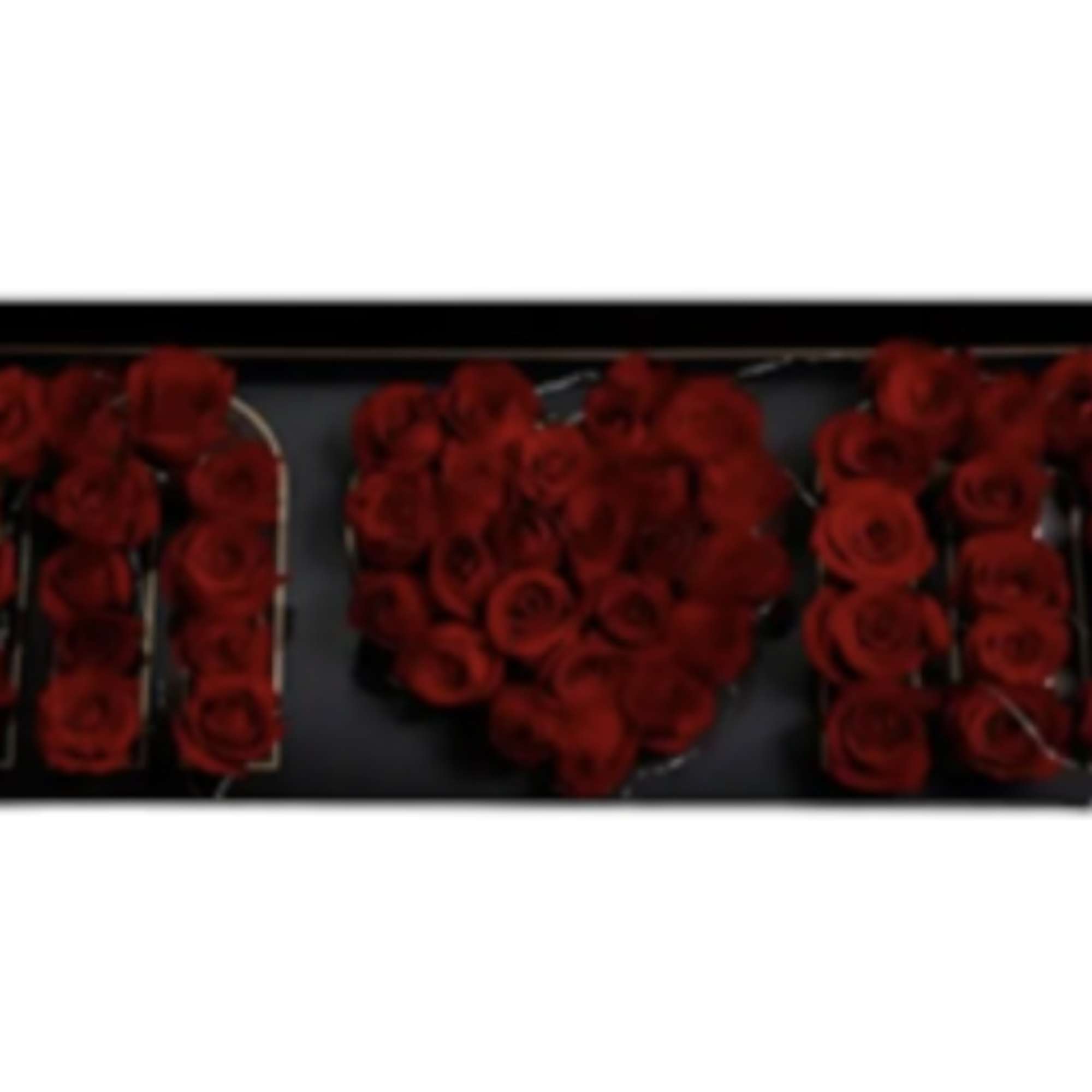 Red roses arranged to spell "MOM" in a black frame