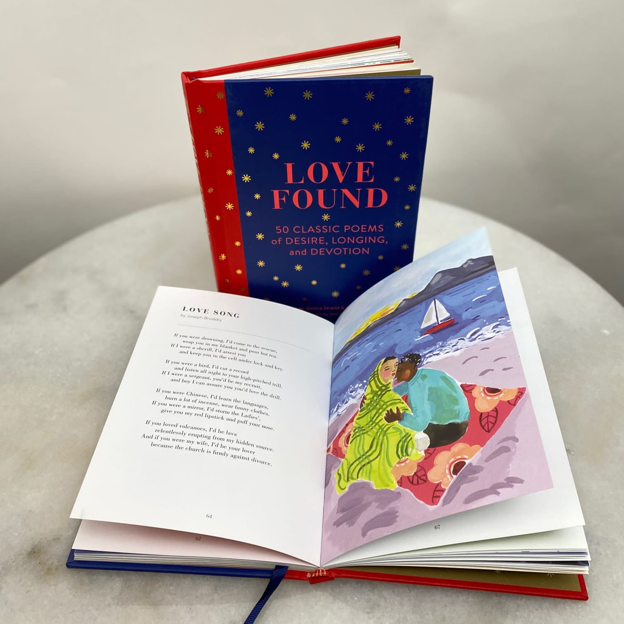 Open poetry book with a blue and red cover on a table