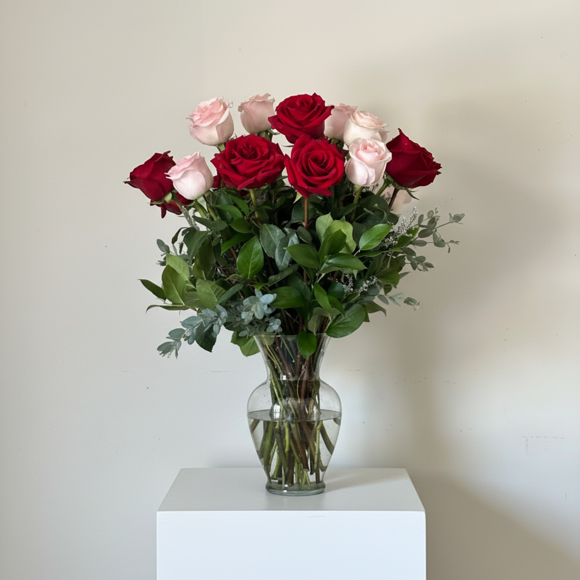 "A romantic blend of classic red and soft blush roses arranged with