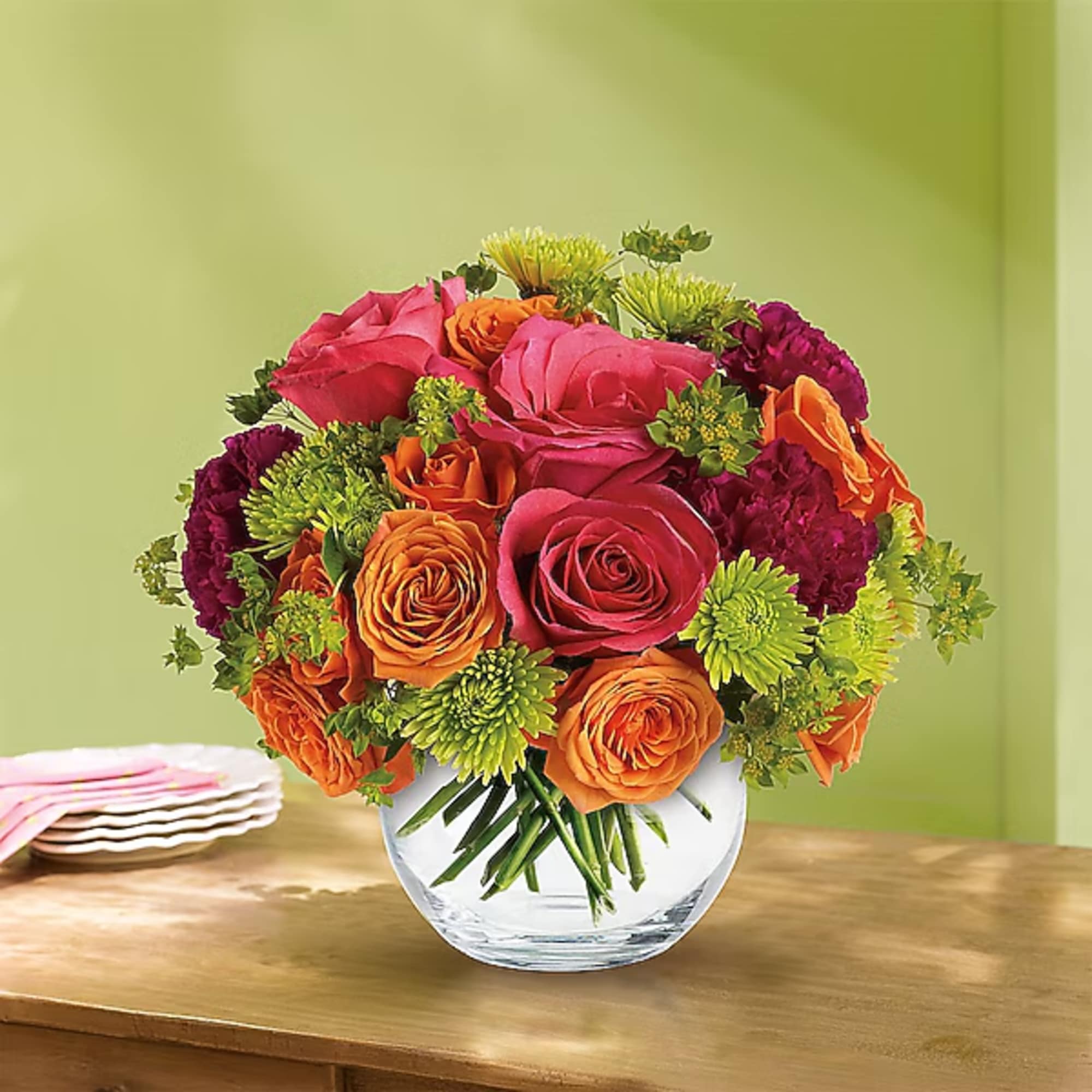 Bouquet of pink and orange roses in a clear glass vase