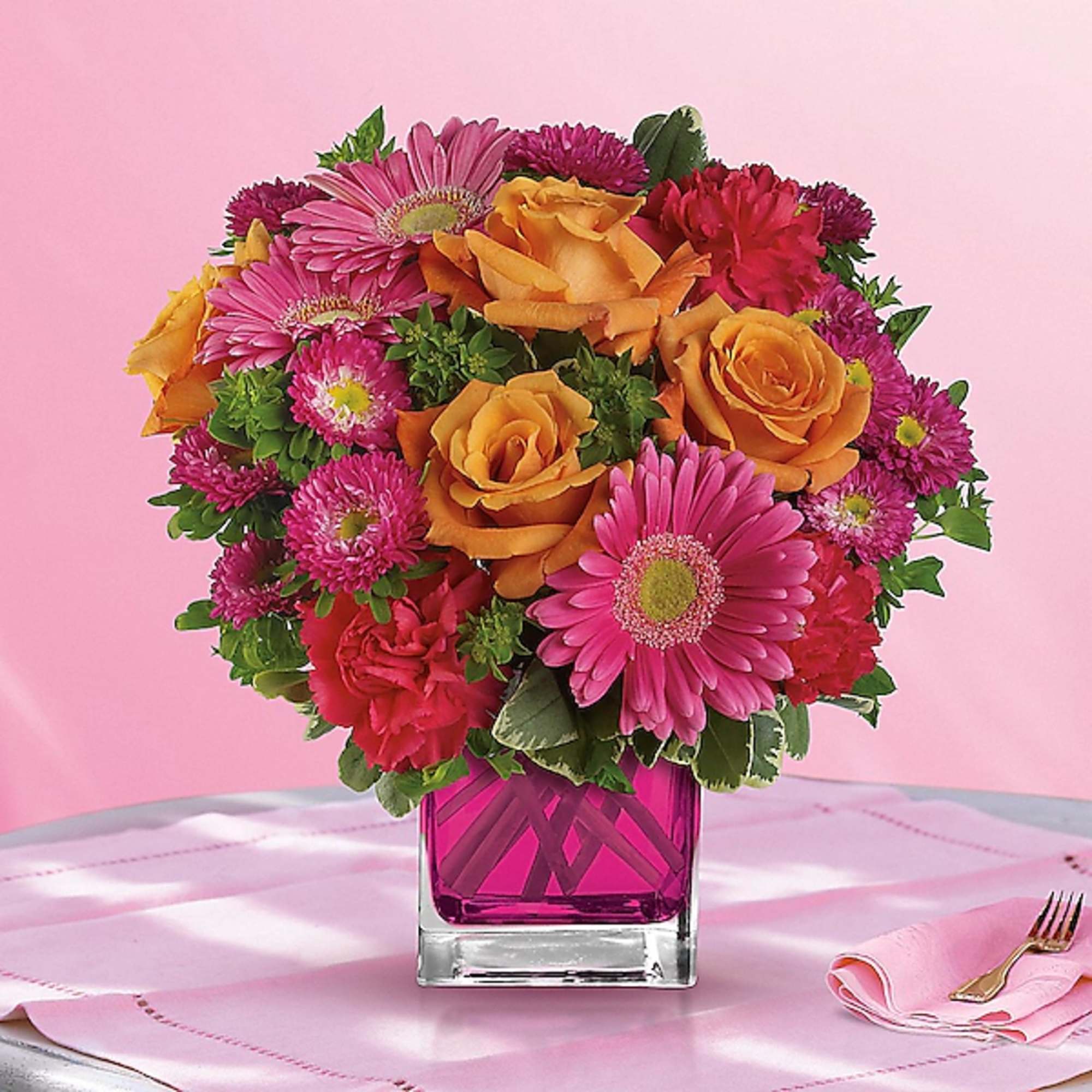 Pink and orange mixed bouquet in a square glass vase