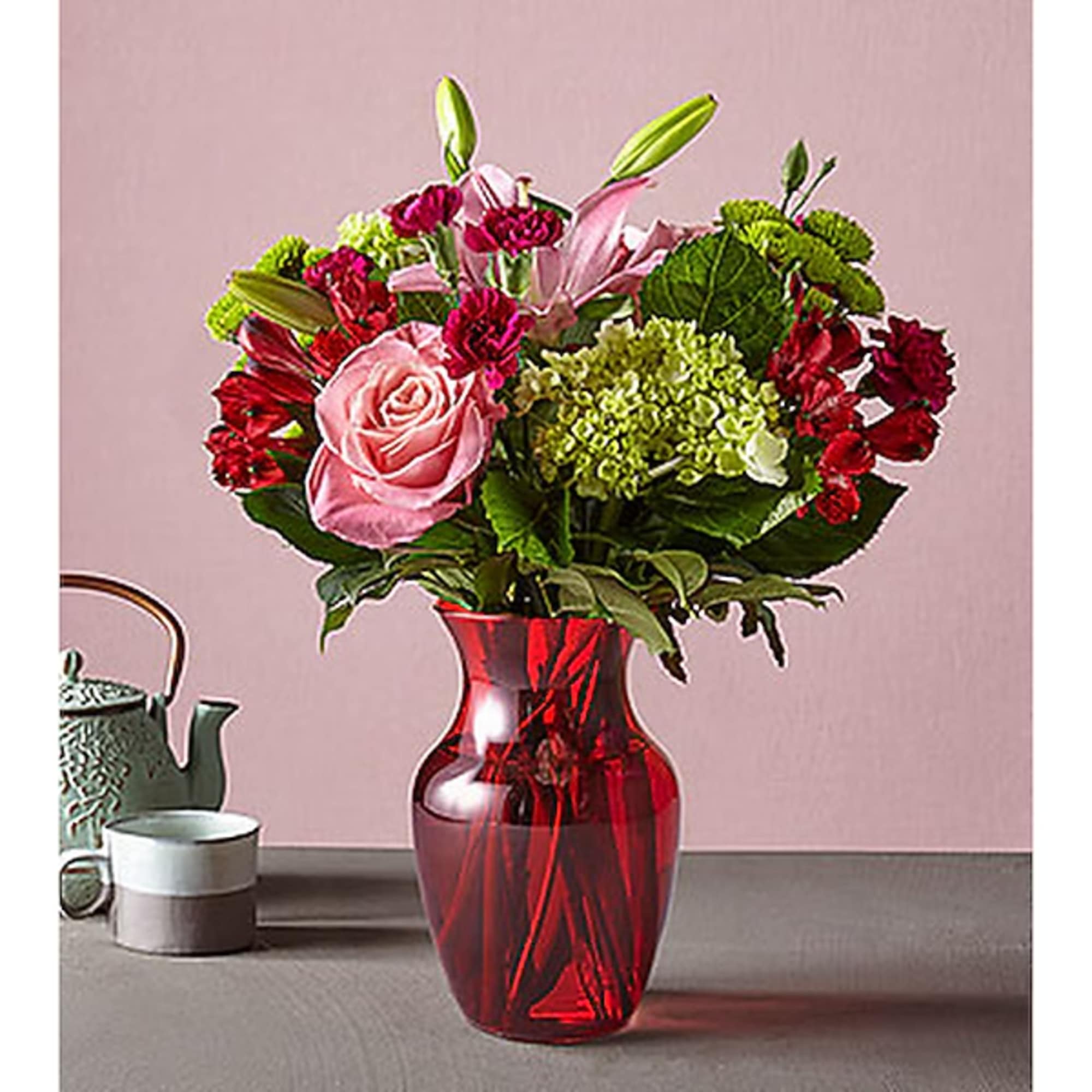 Pink and red mixed bouquet in a red glass vase