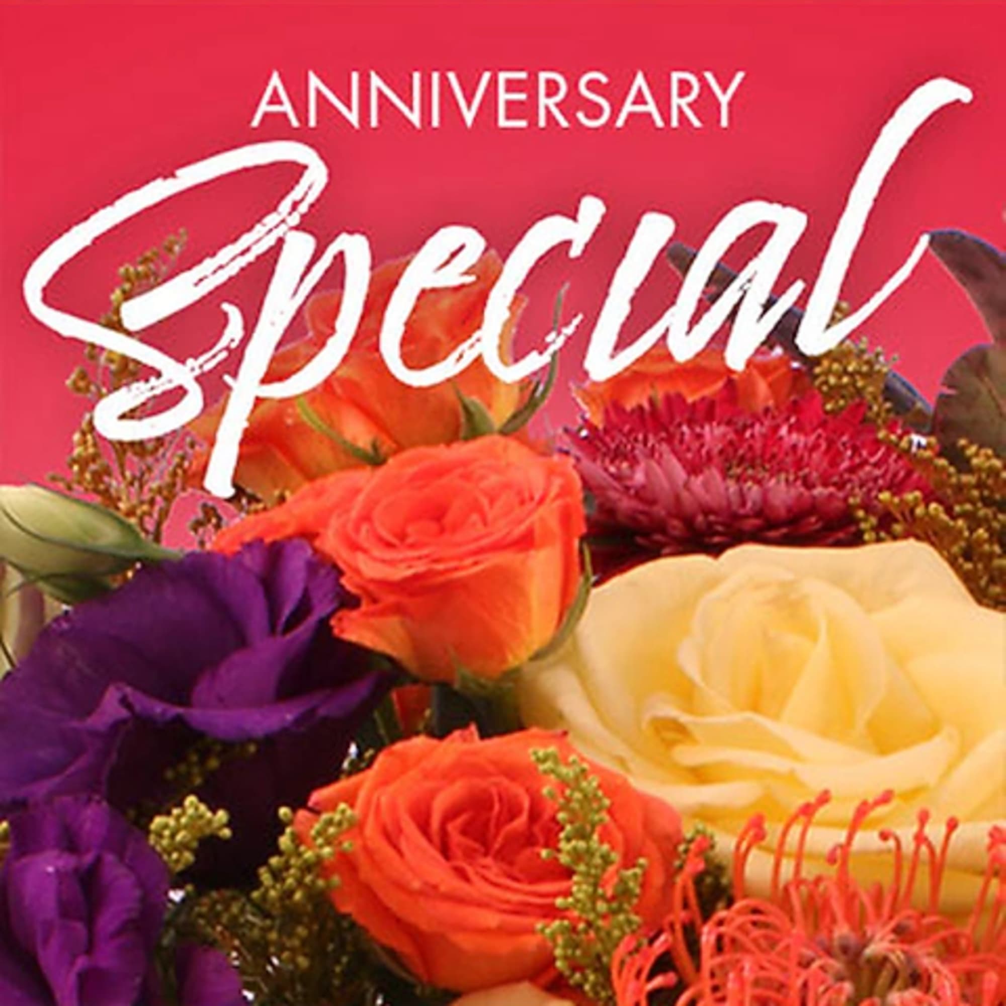 Mixed bouquet of roses and purple blooms with an anniversary card