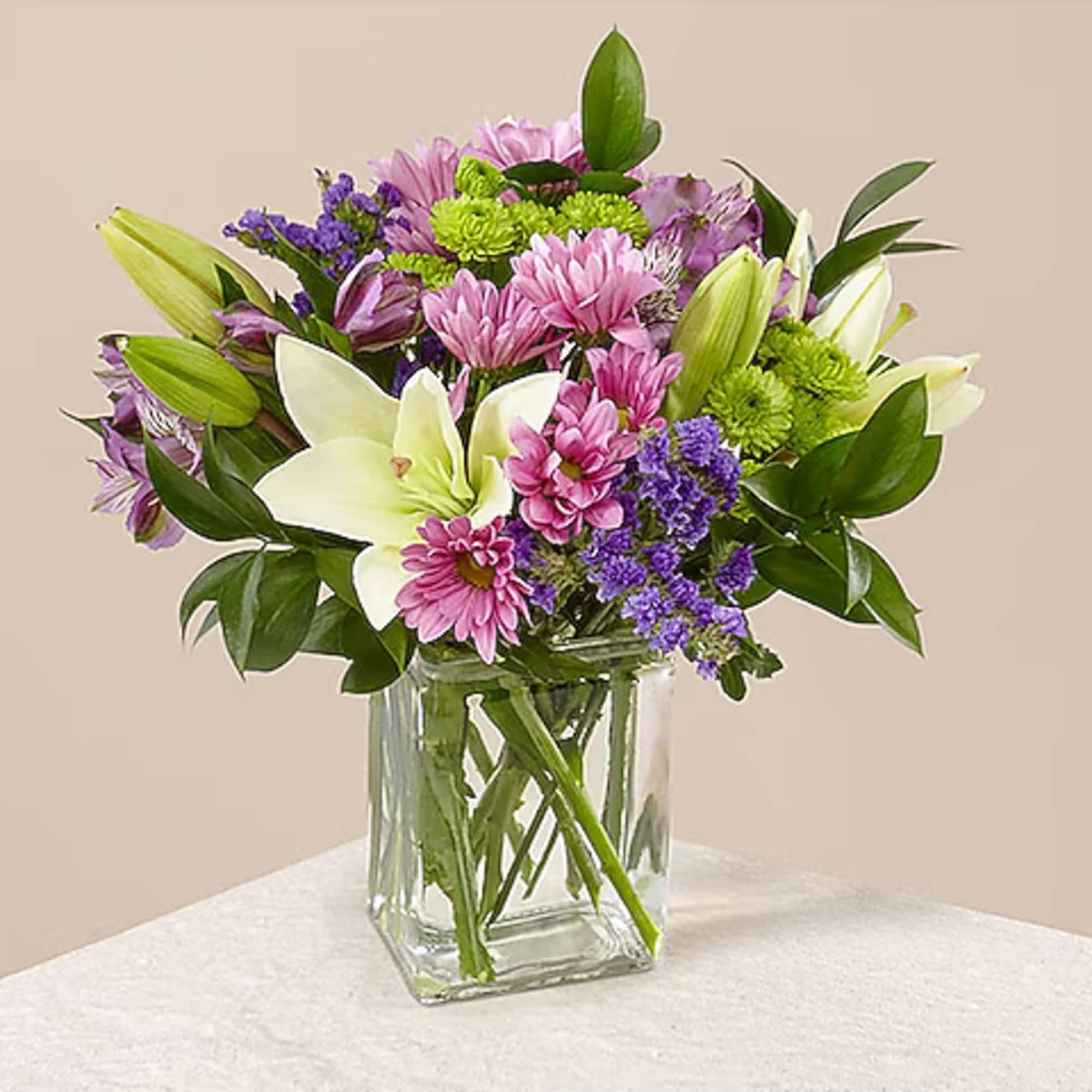 Mixed pink and purple flowers in a clear glass vase