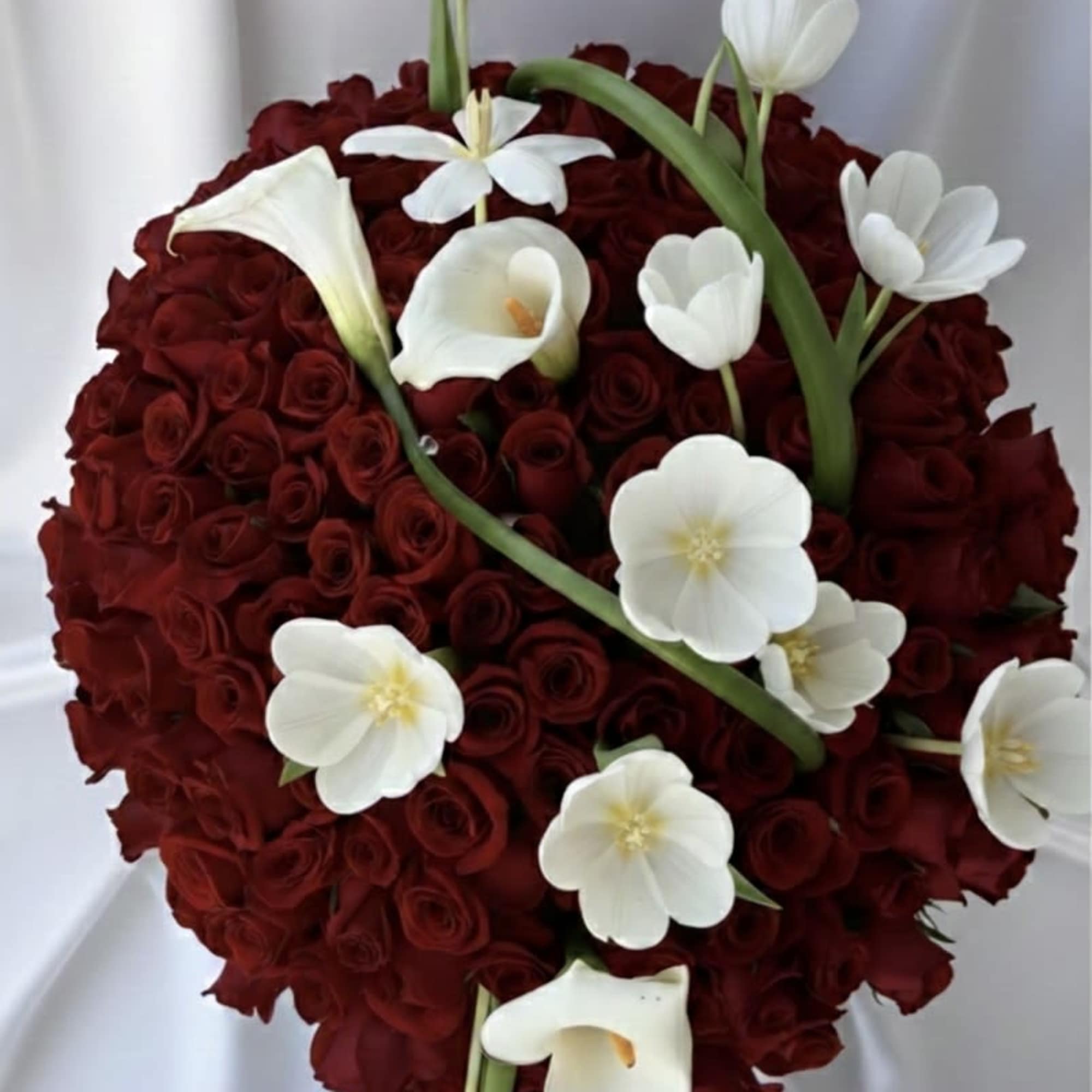 Heart-shaped bouquet of red roses with white calla lilies and tulips