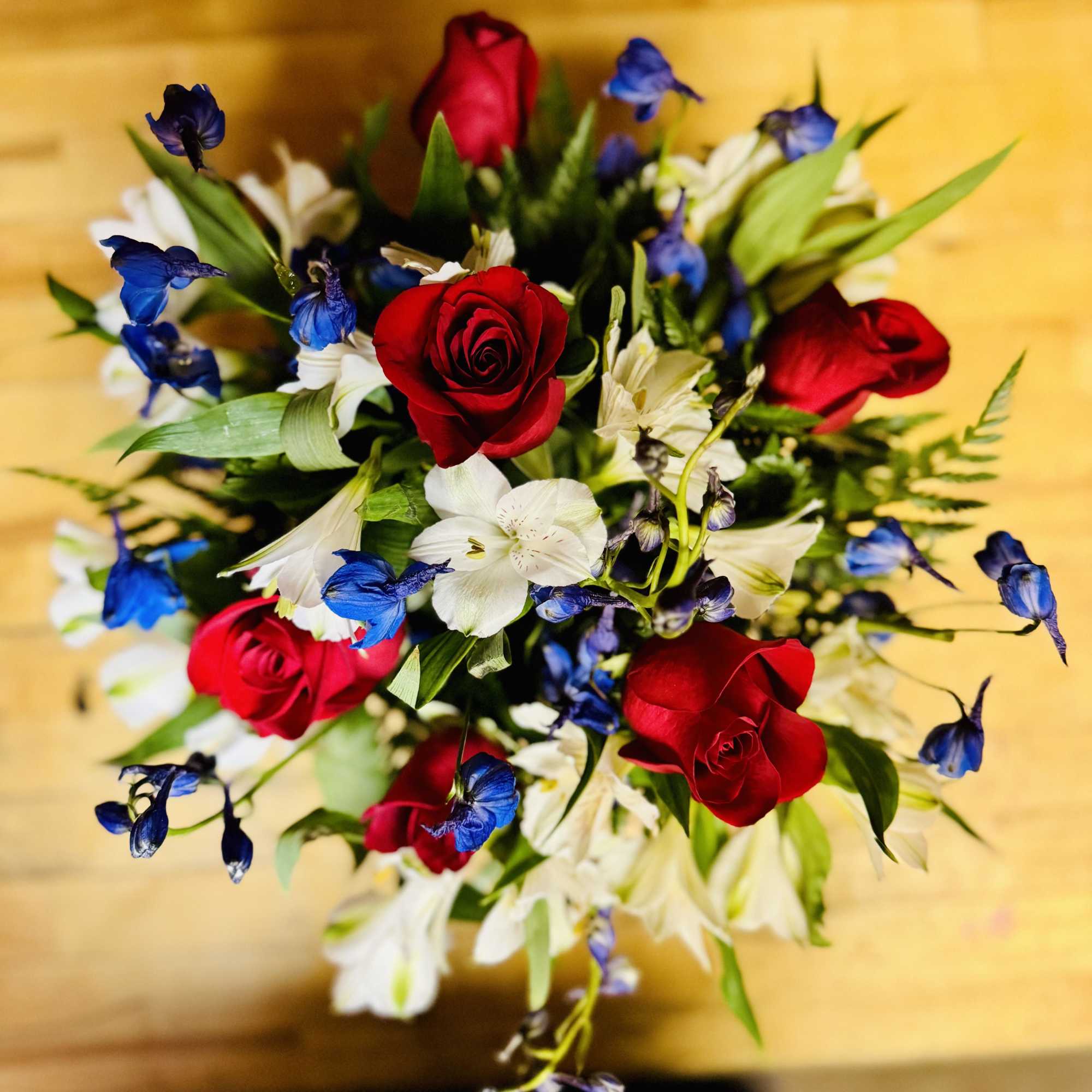 Bouquet of red roses, white lilies, and blue flowers