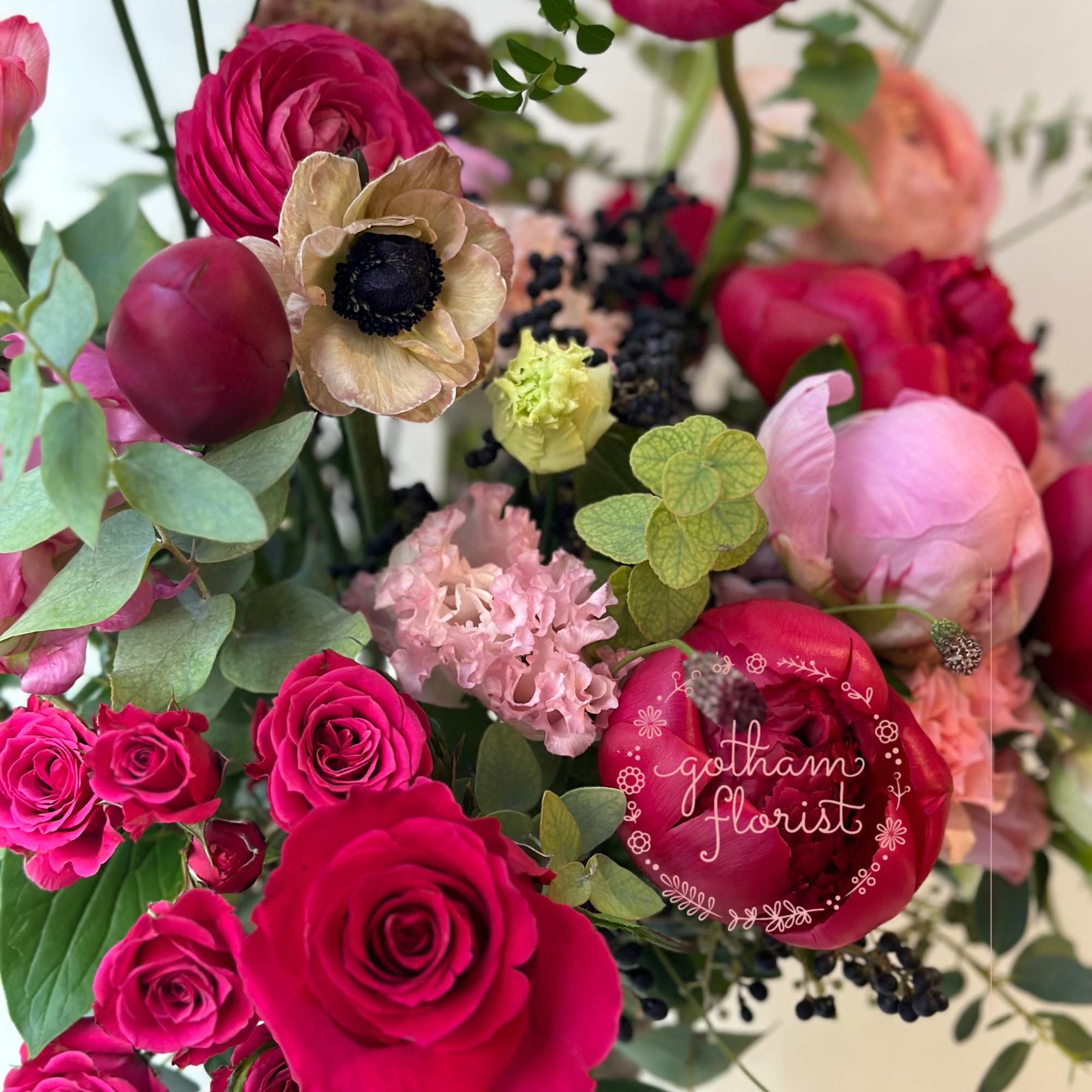 Bouquet of hot pink roses, ranunculus, and pale pink blooms