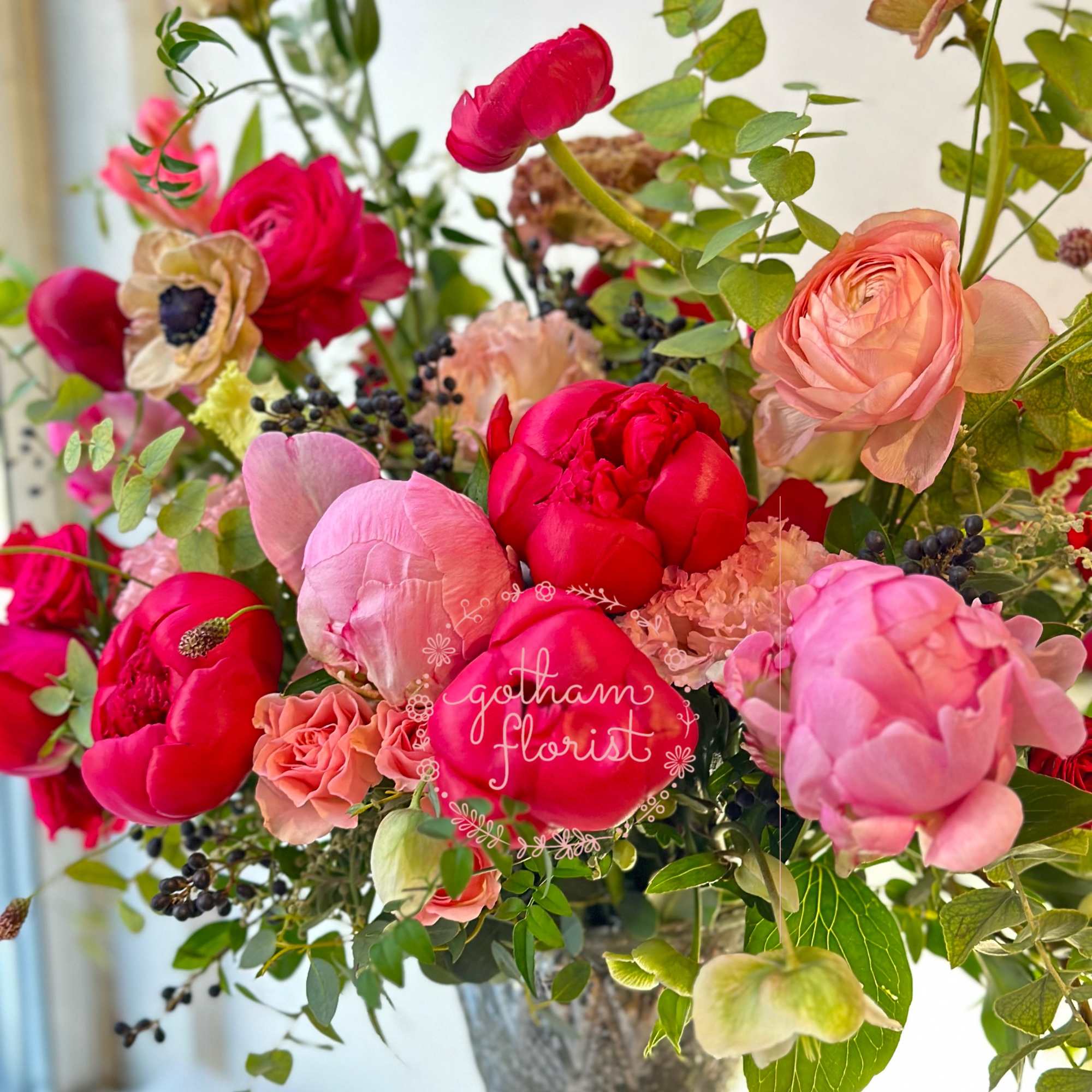 Pink and coral flowers arranged in a silver vase