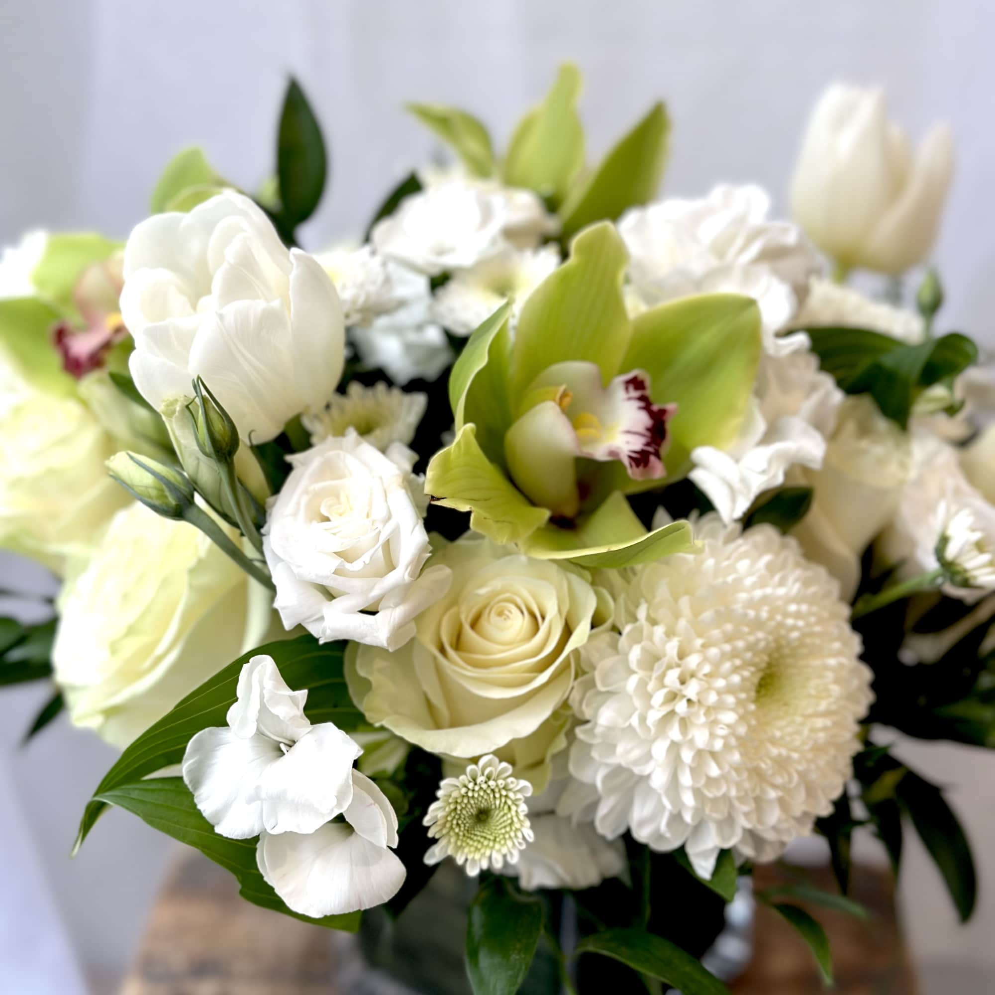 White and pale green bouquet with roses, orchids, and mums