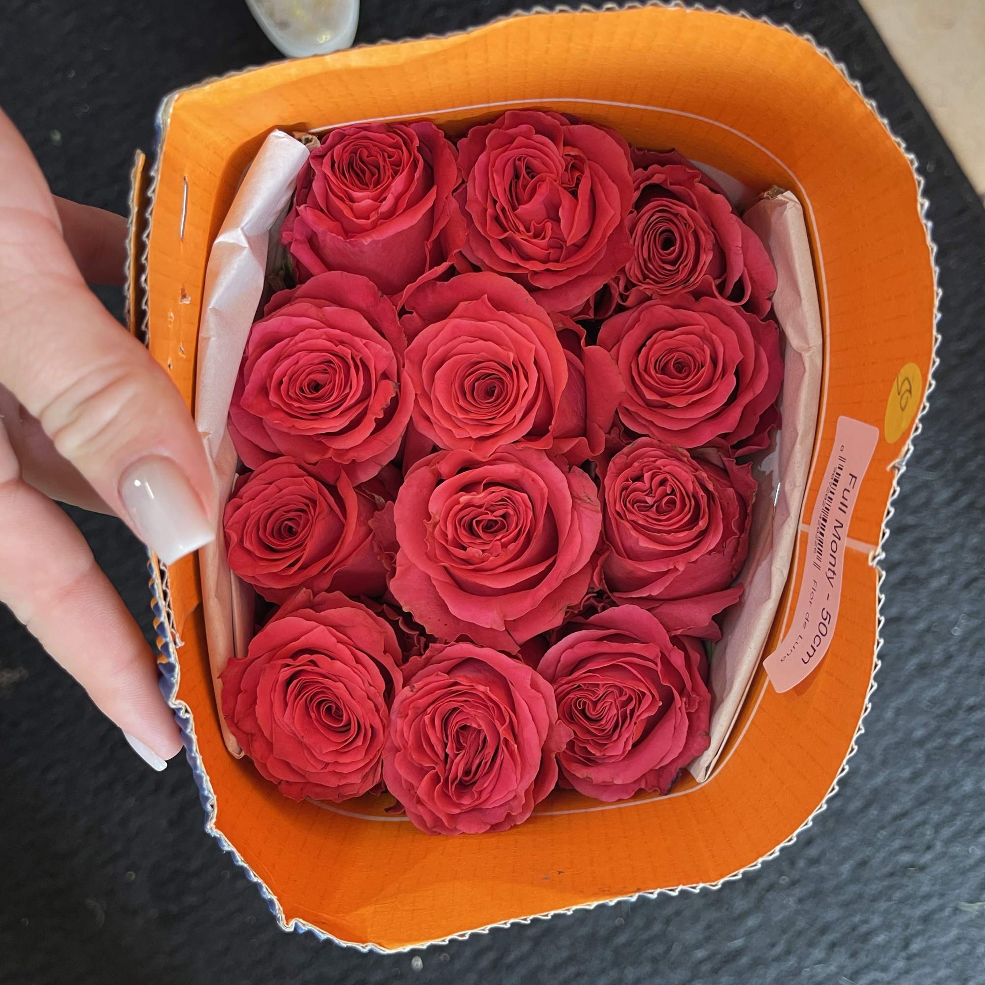 A small box of bright pink roses arranged tightly together