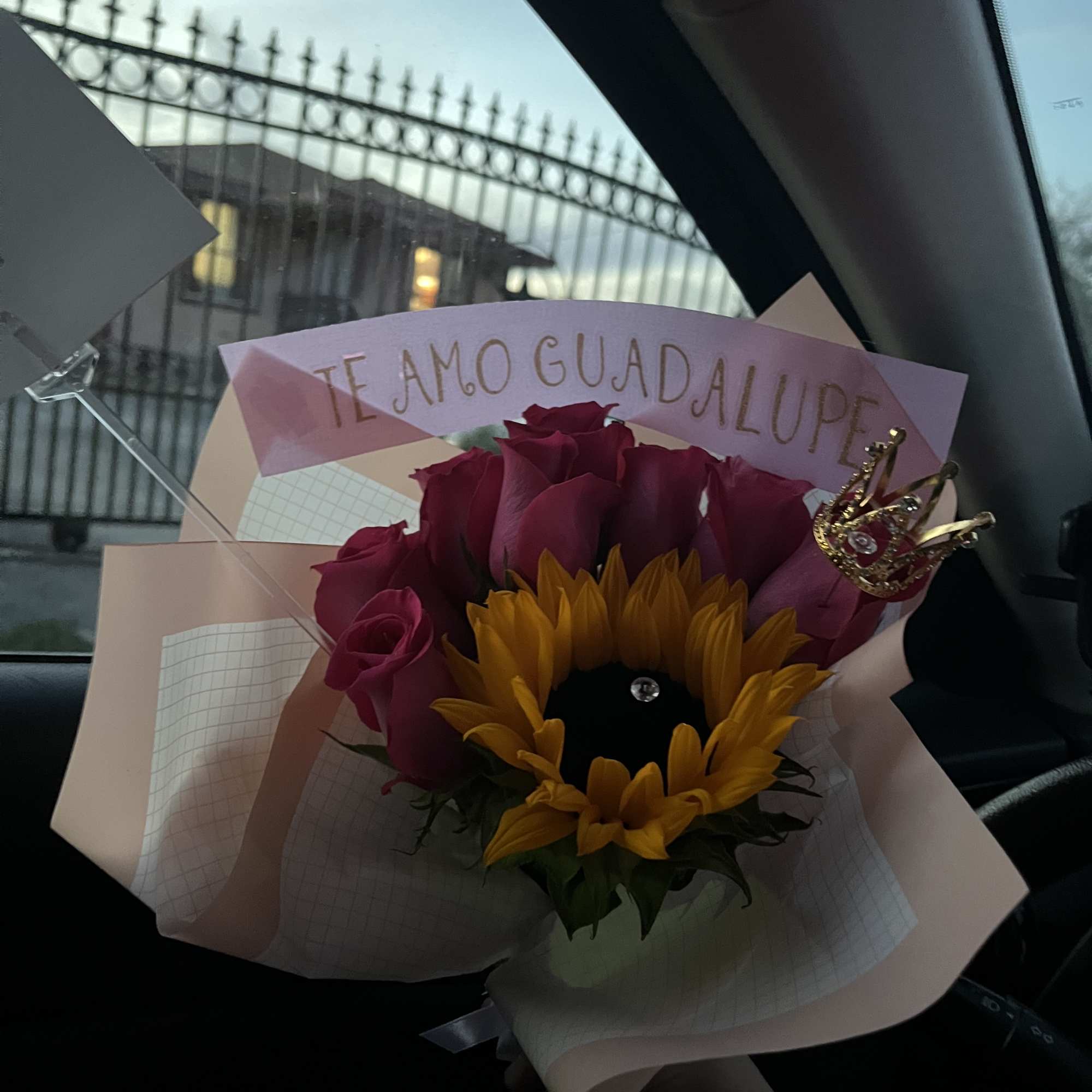 Bouquet of pink roses and a sunflower with a decorative topper