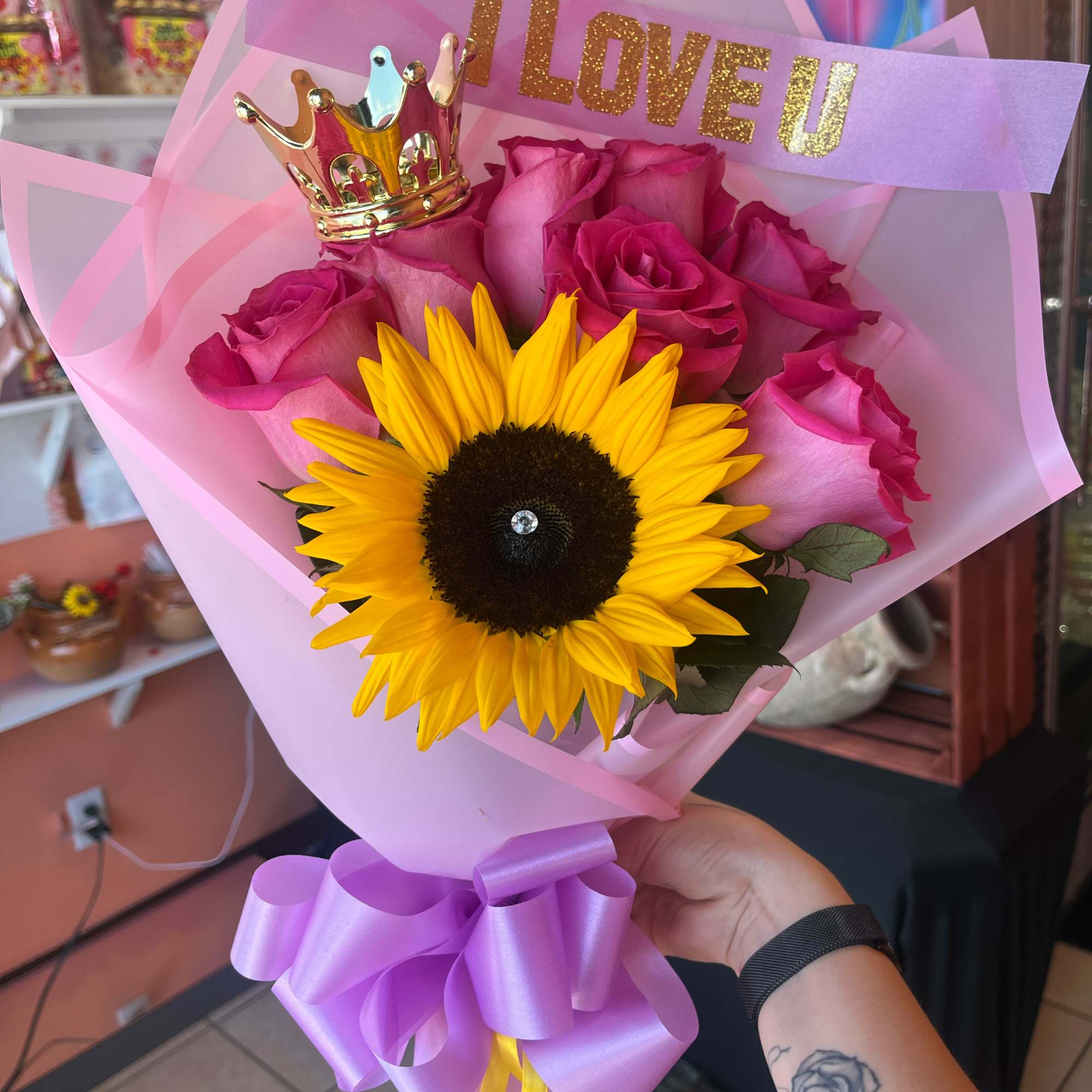 Pink rose bouquet with a sunflower, crown topper, and "I LOVE U" sign