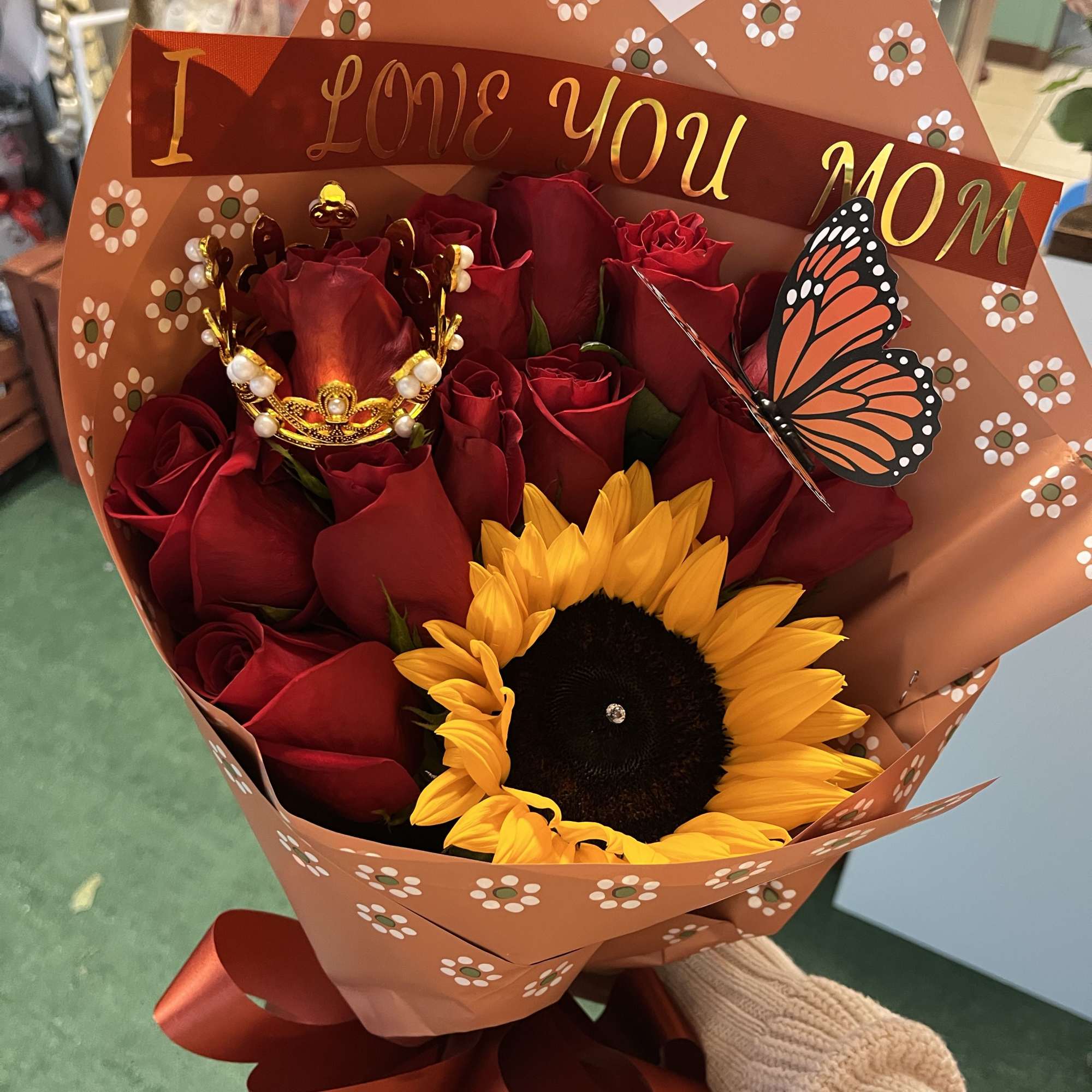 Bouquet of red roses and a sunflower with a "I LOVE YOU MOM" topper