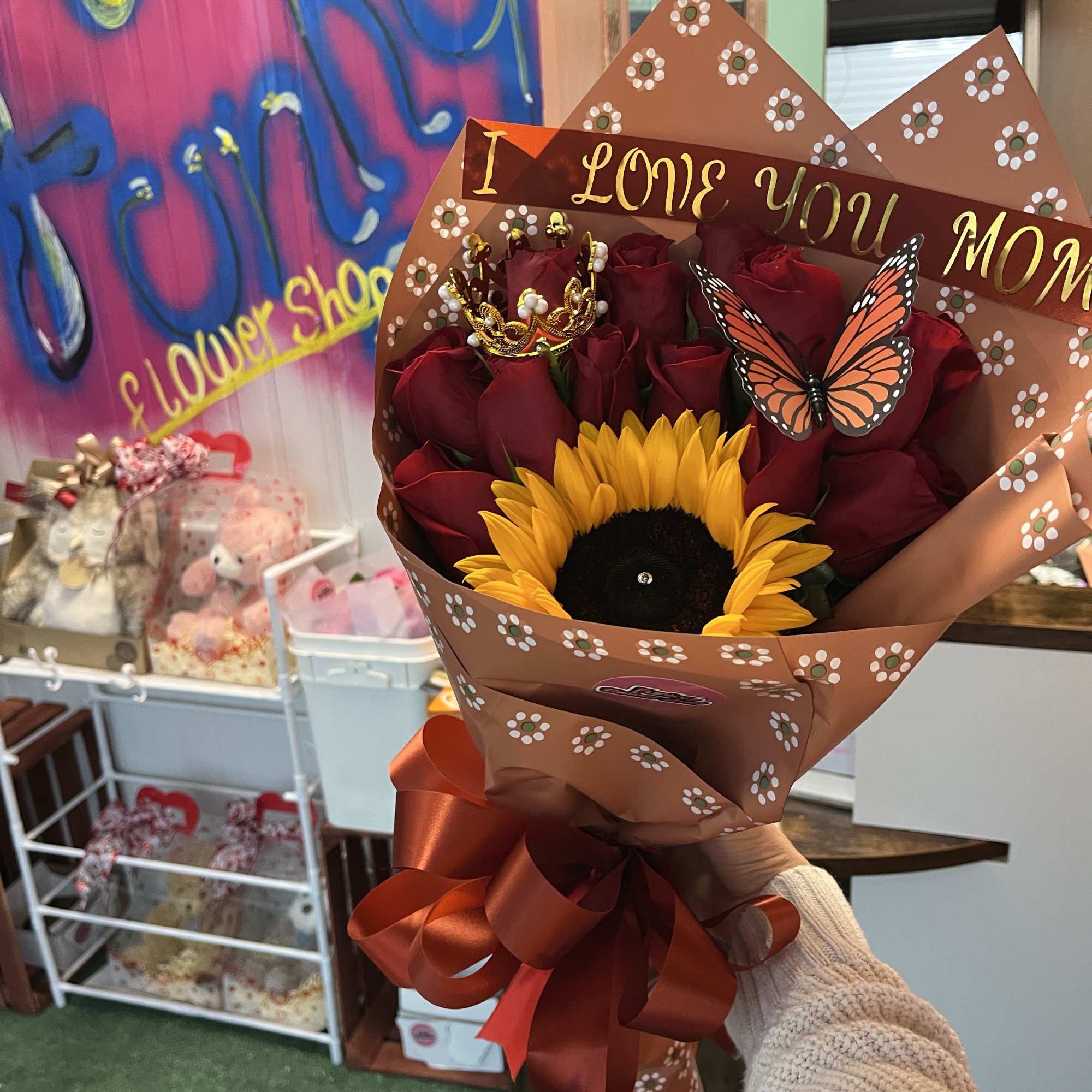 Bouquet of red roses and a sunflower in decorative wrap