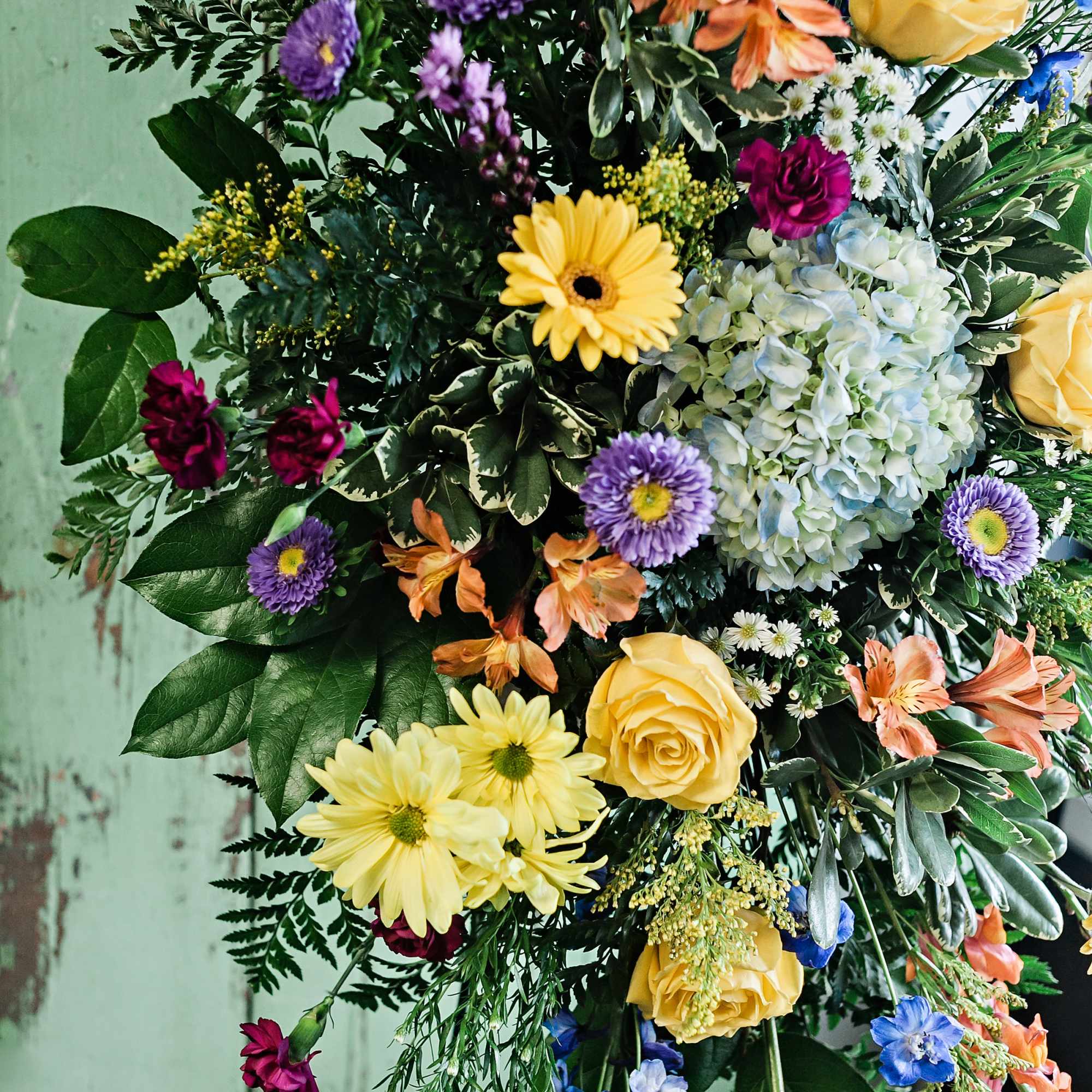 Colorful mixed flower arrangement with roses, daisies, and hydrangea