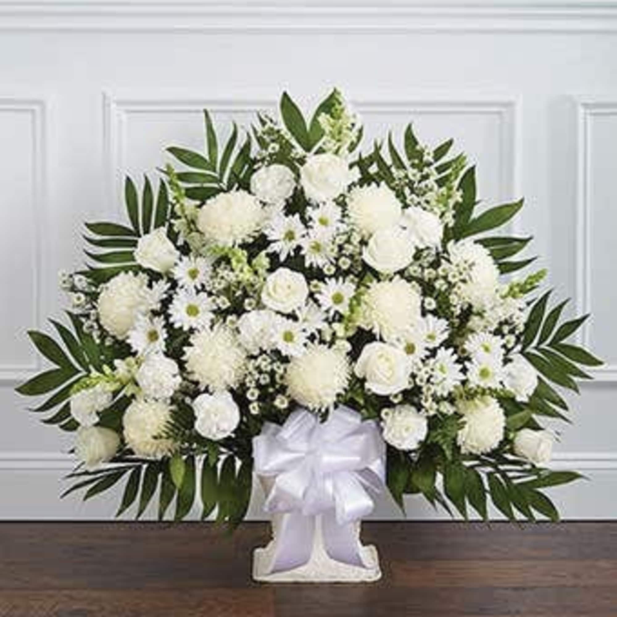 White funeral spray with daisies and roses on a stand