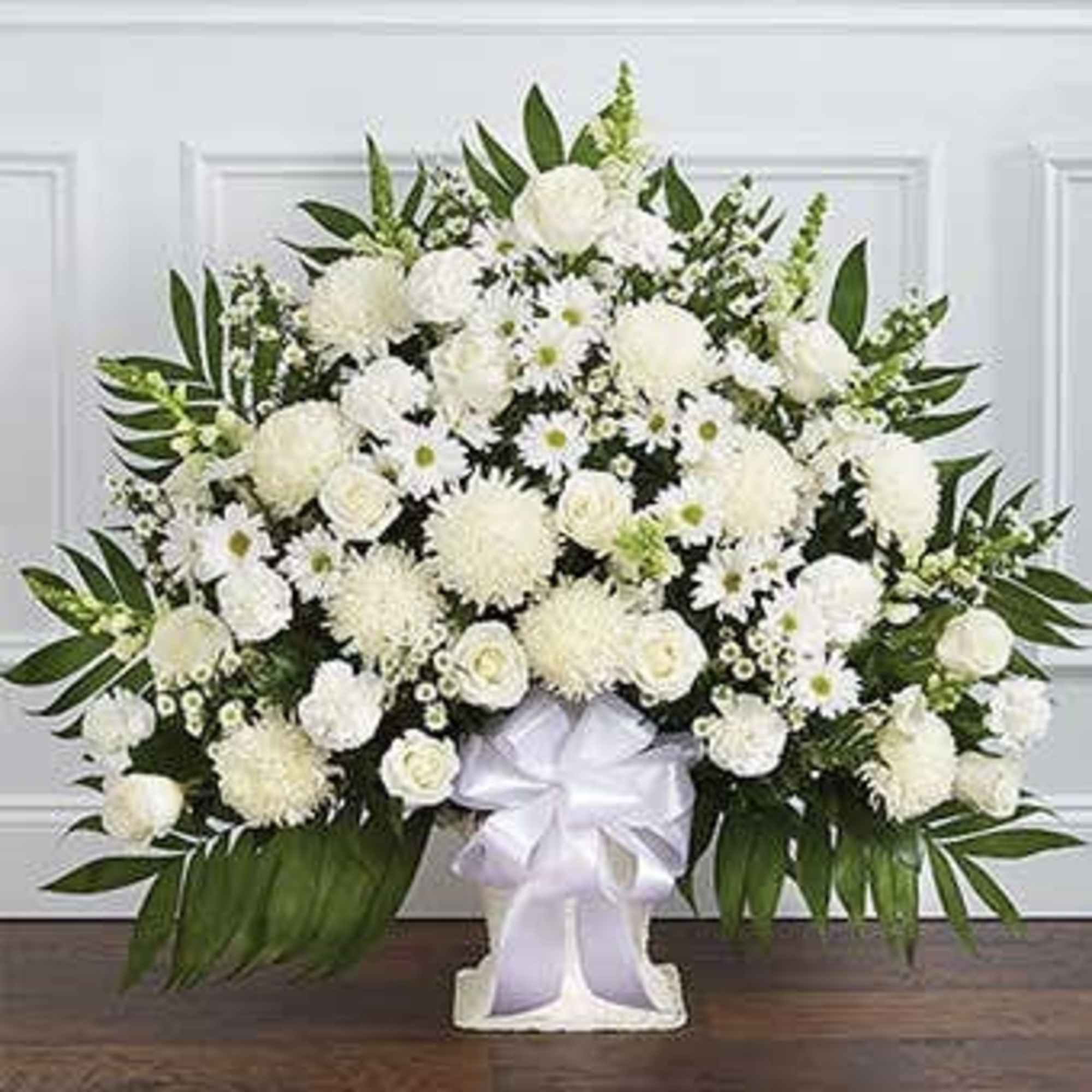 White floral standing spray with a ribbon bow