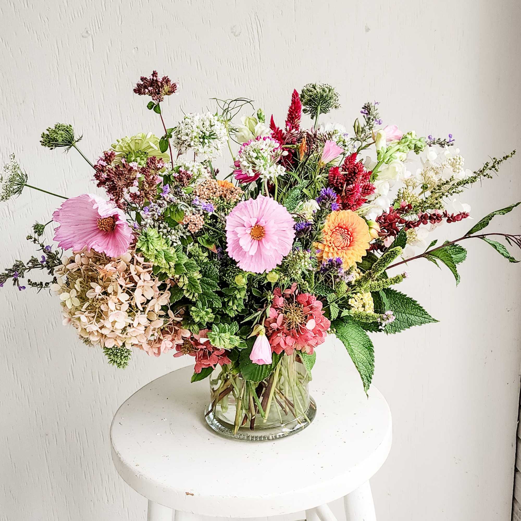 Mixed bouquet in a clear glass vase with pink, white, and orange blooms