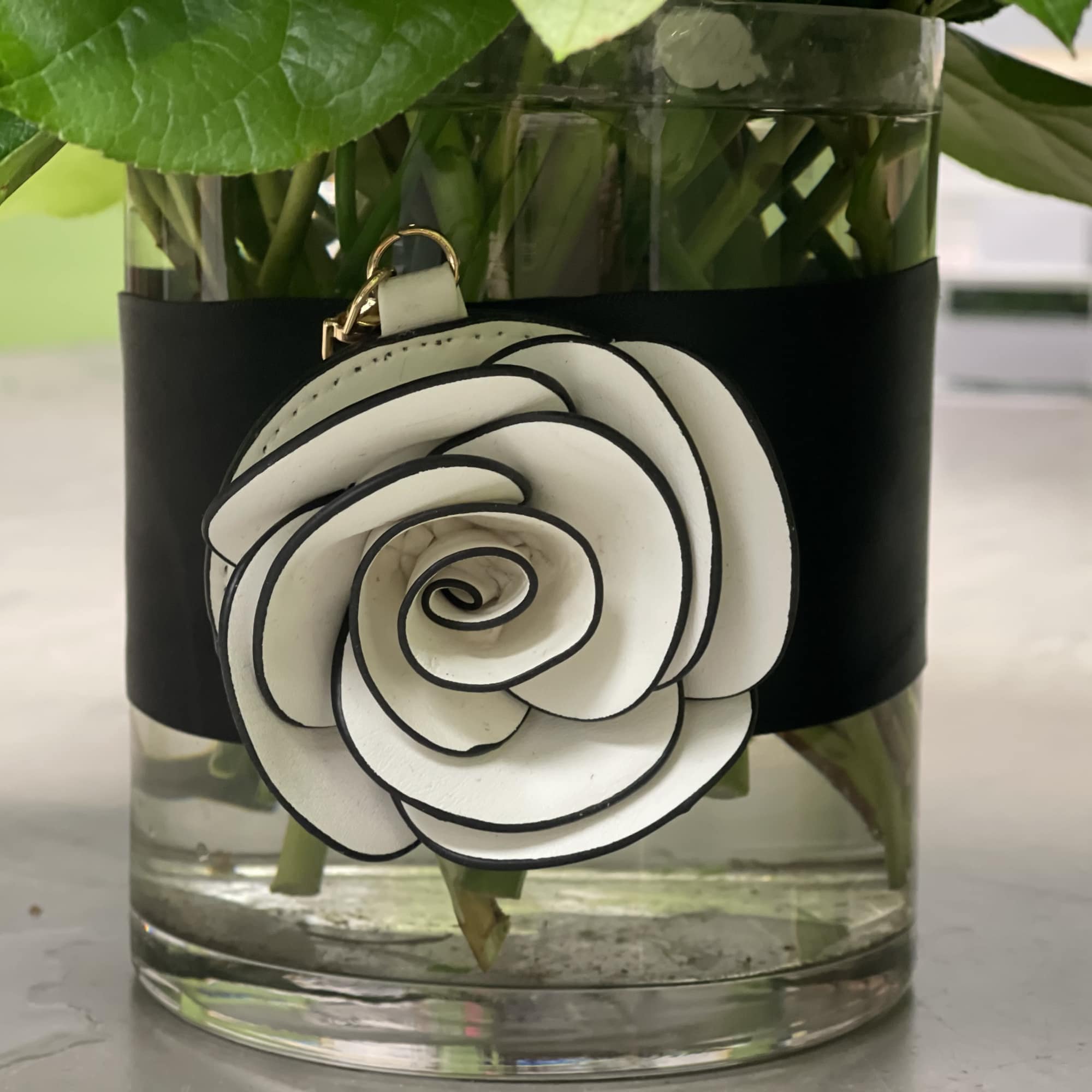 White spiral flower accessory on a glass vase with black wrap