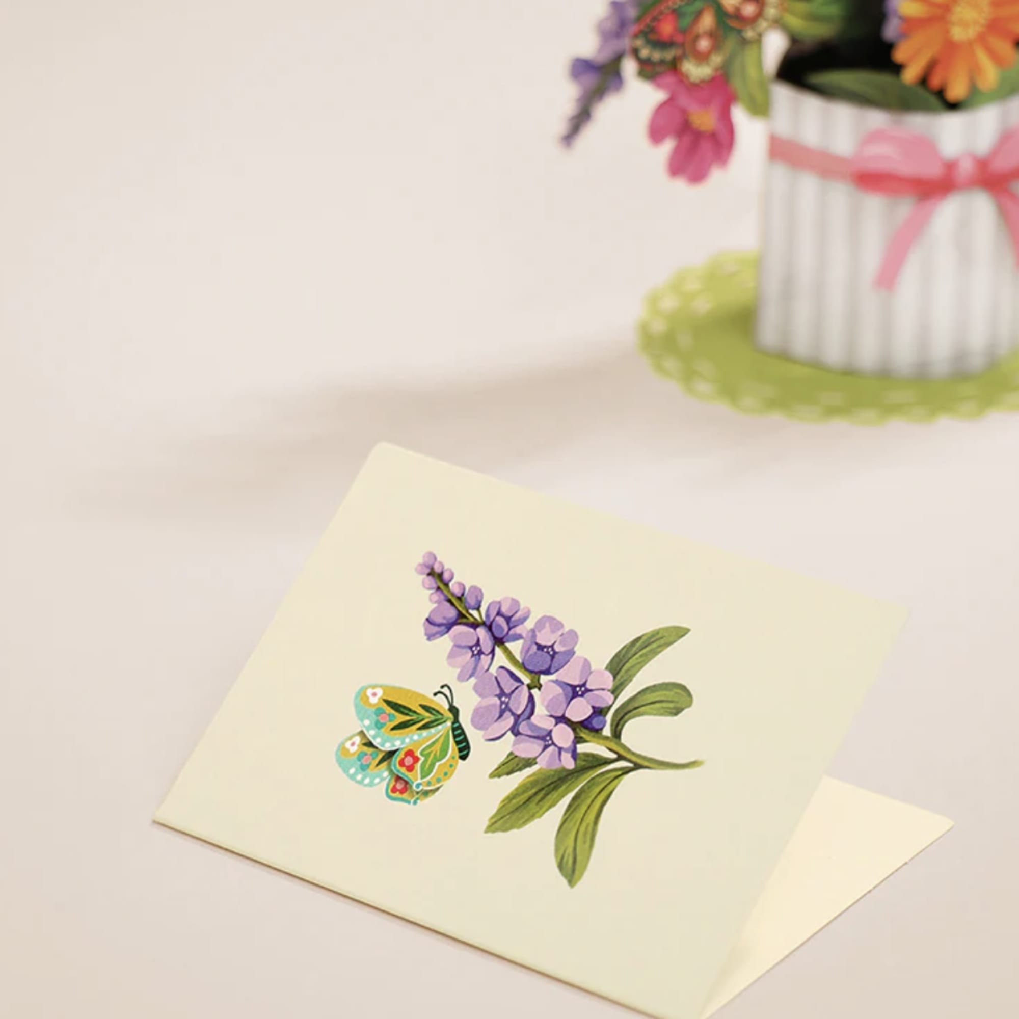 Greeting card with a purple flower and colorful butterfly illustration