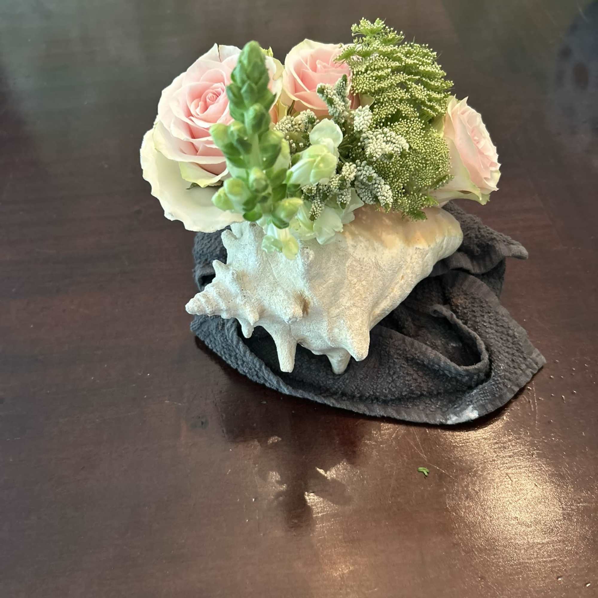 A Genuine Bahaman Conch stuffed with roses and a variety mixed seasonal