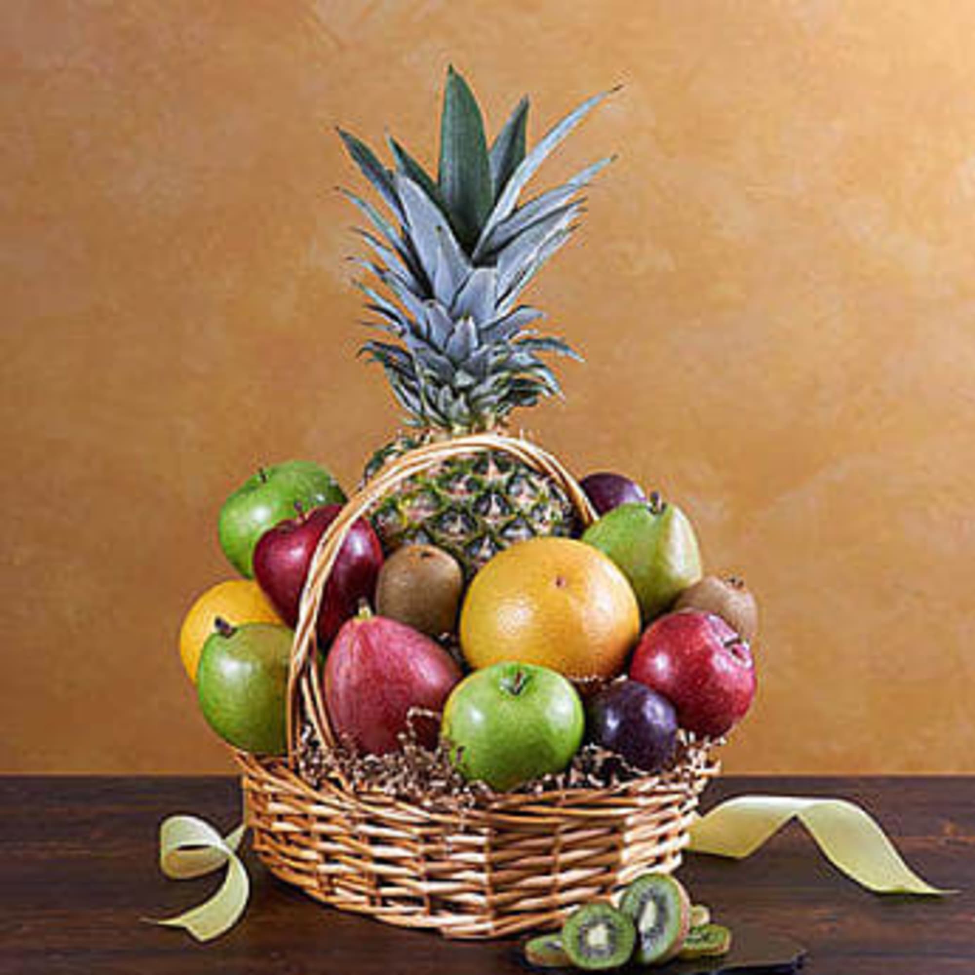 Fruit basket with a pineapple and assorted apples in a wicker basket