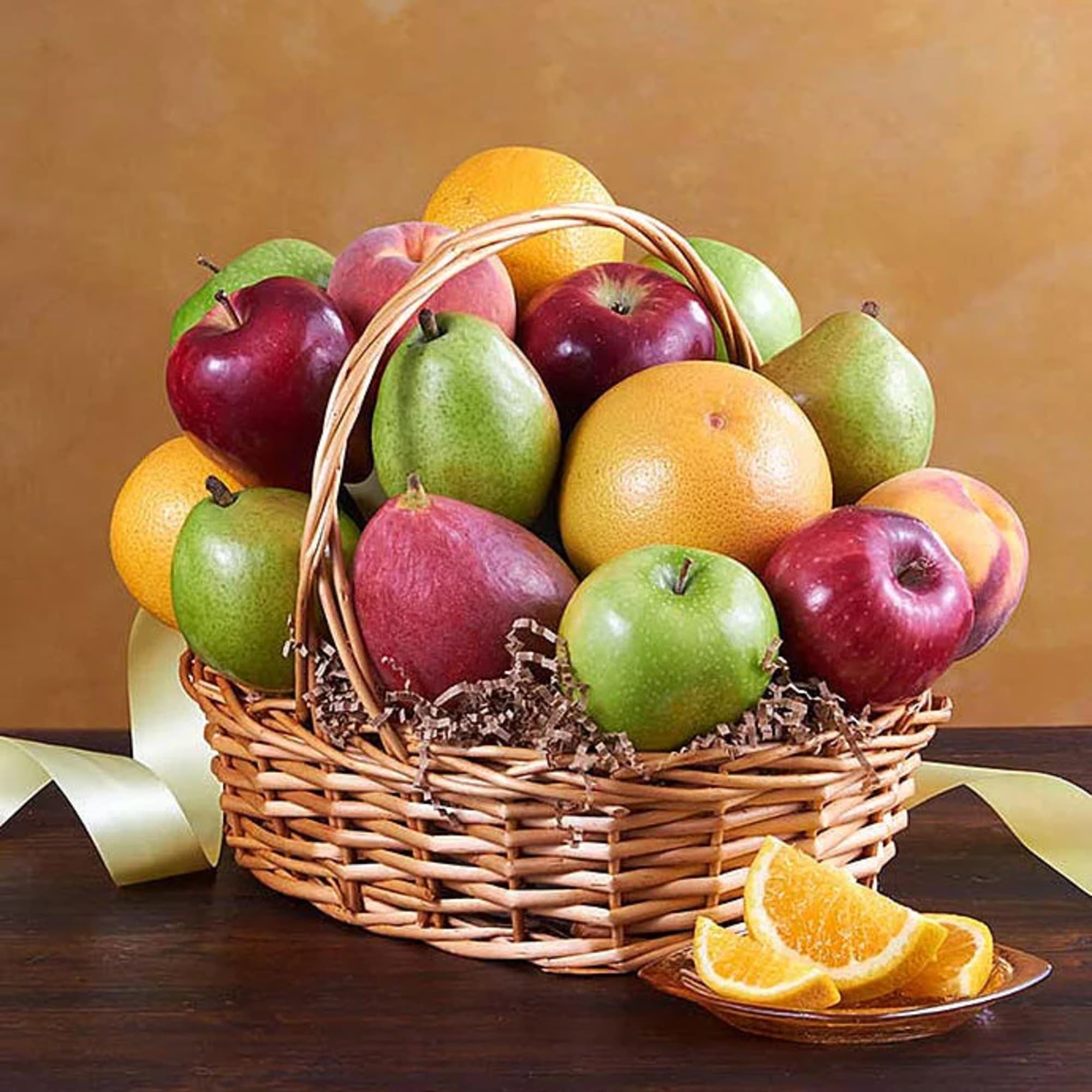 Basket of assorted fruit with orange slices on a plate