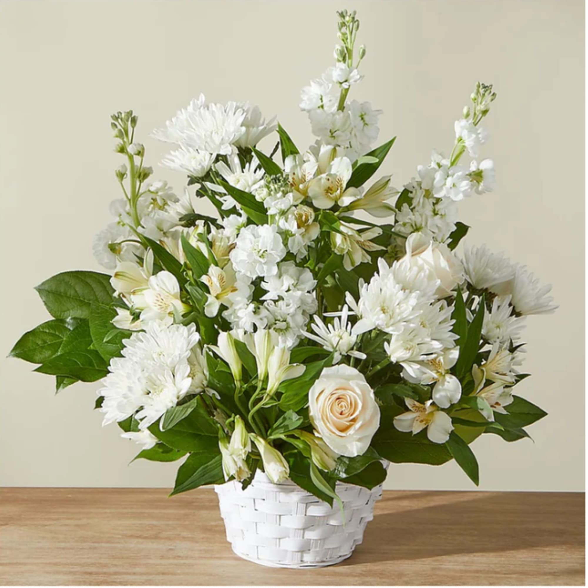 White floral arrangement in a white woven basket