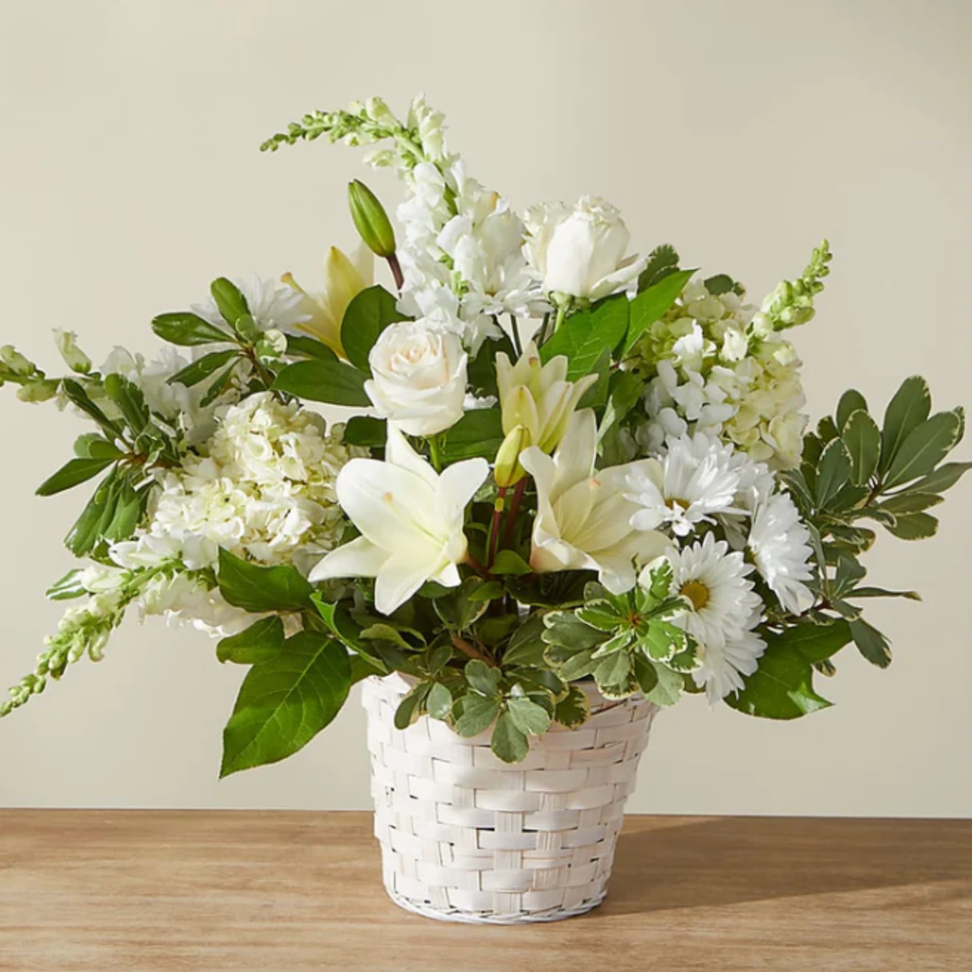 White floral arrangement in a white woven basket