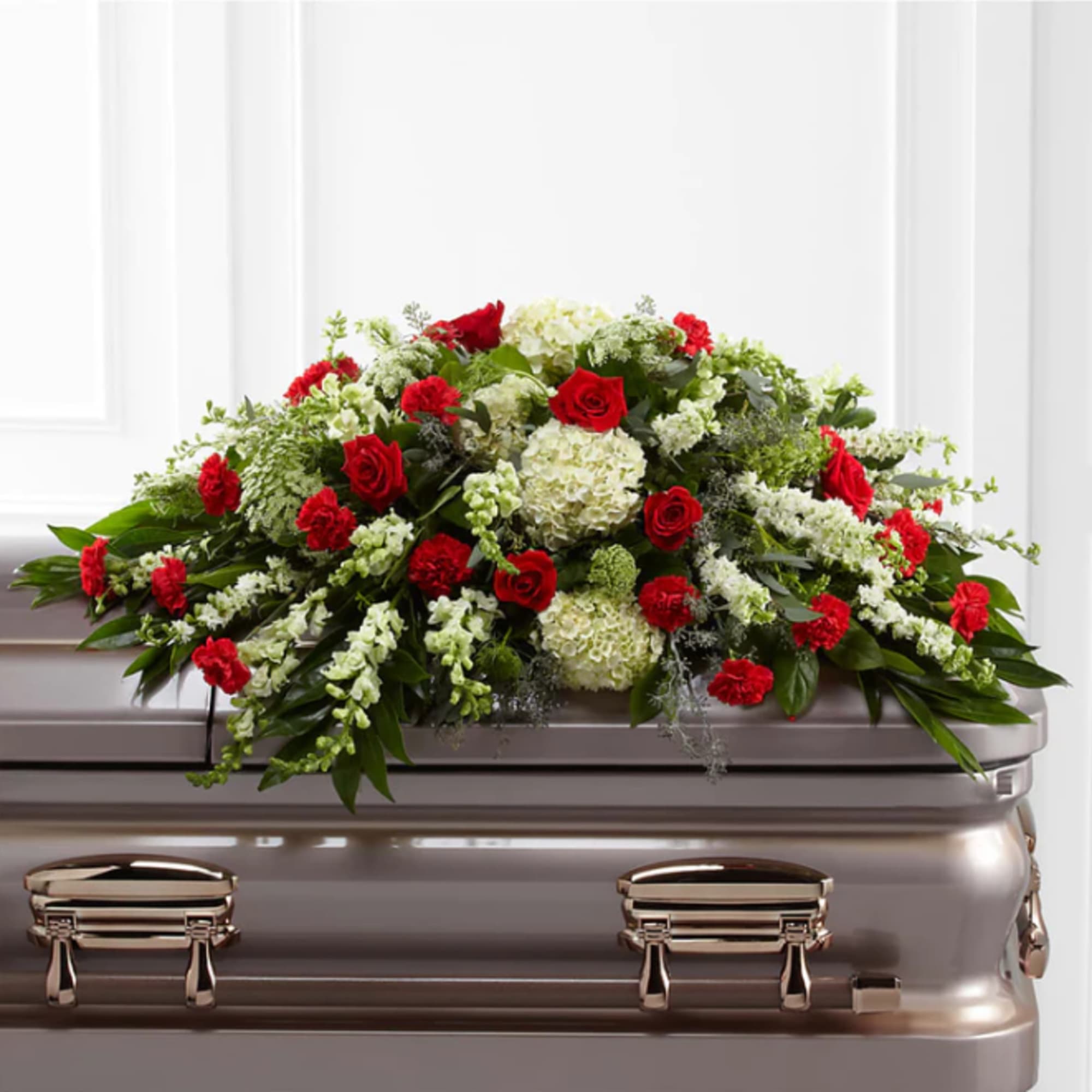 Red roses and white flowers arranged on a casket