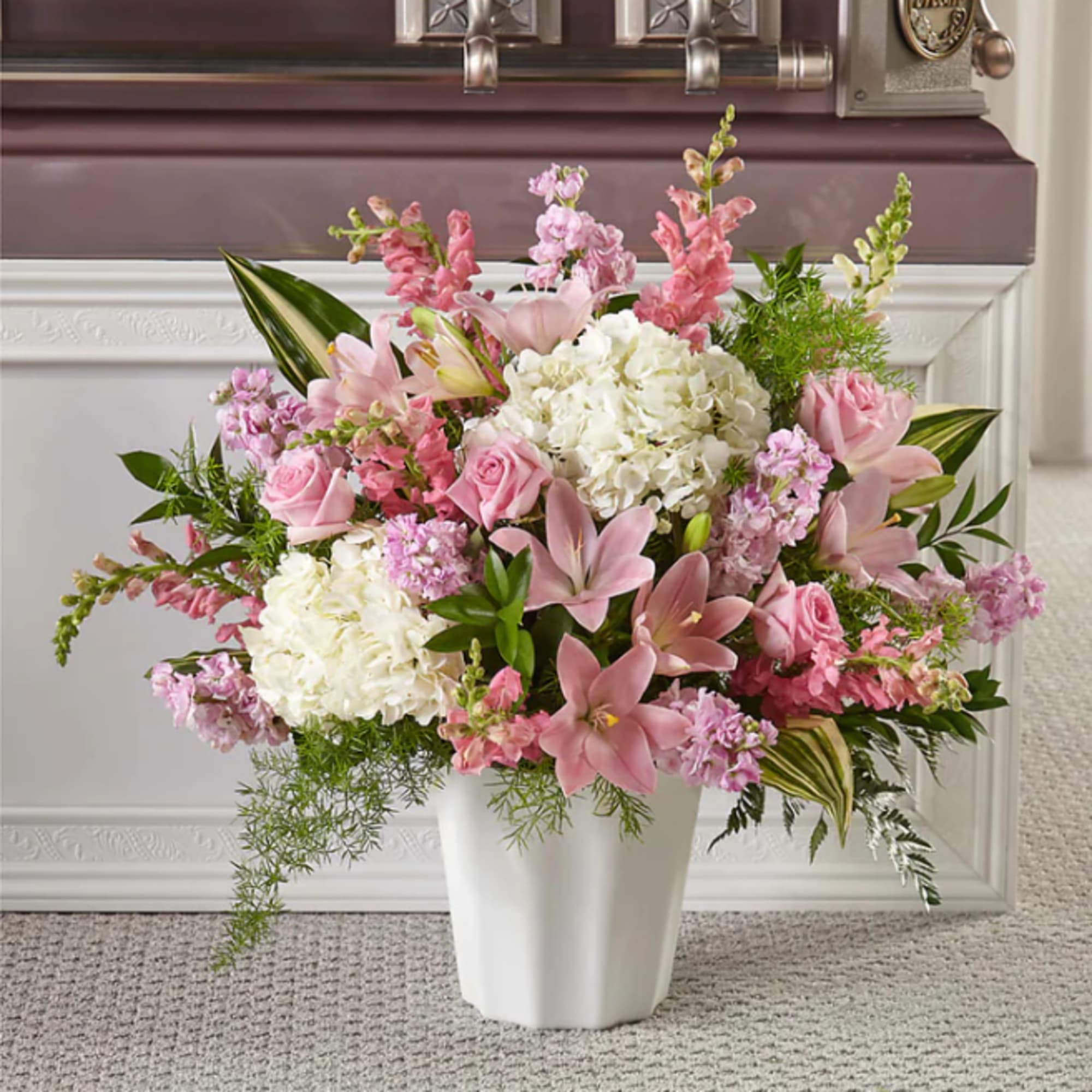 Pink and white floral arrangement in a white vase