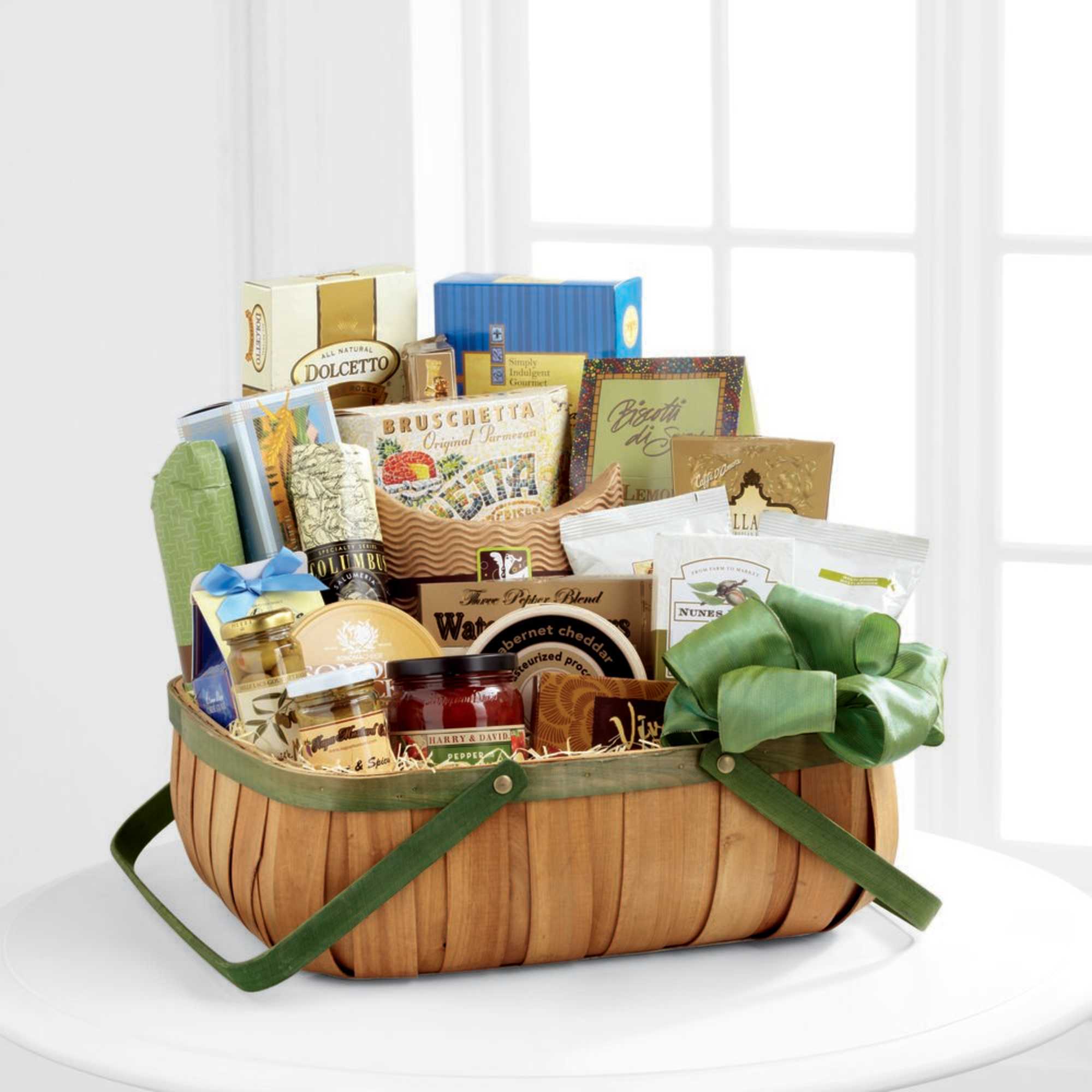 Basket of assorted gourmet snacks and packaged foods with a green ribbon