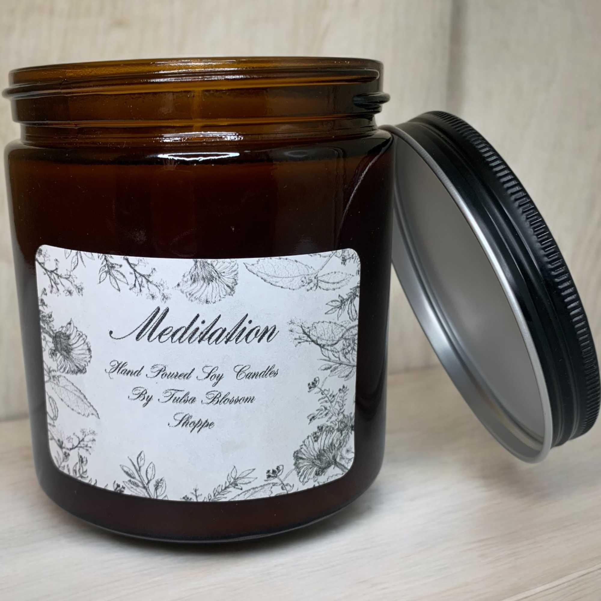 Amber jar candle with a floral label and black lid